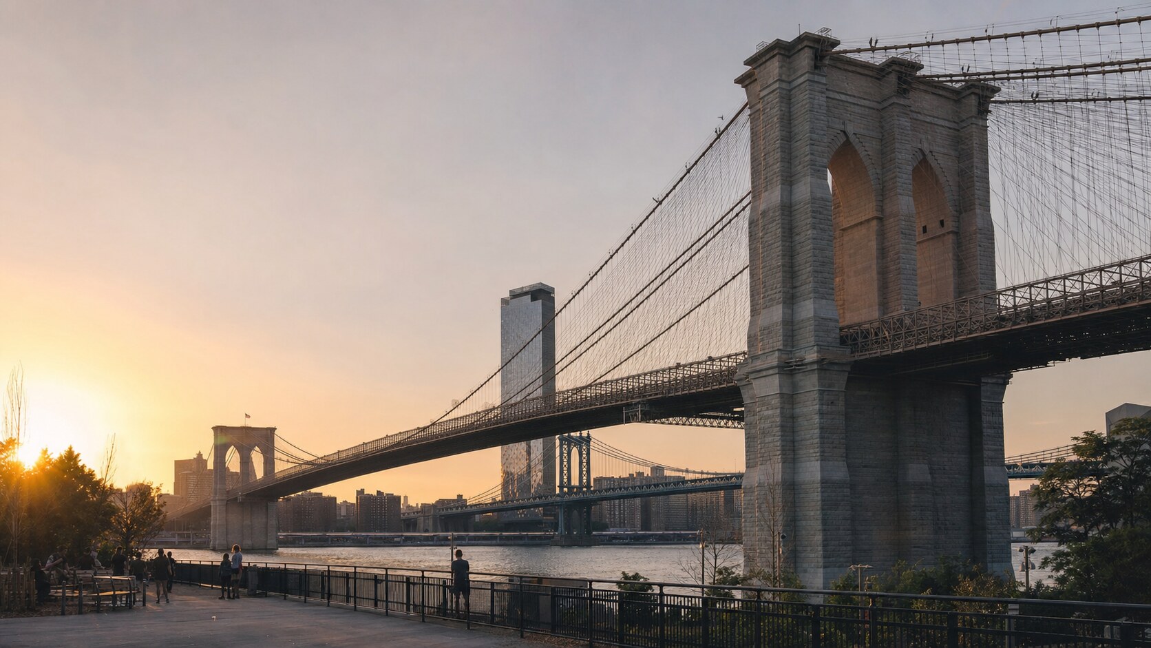 The Brooklyn Bridge photographed at golden hour from the most popular hero-shot vantage point, with dramatic side-lighting on the structure
