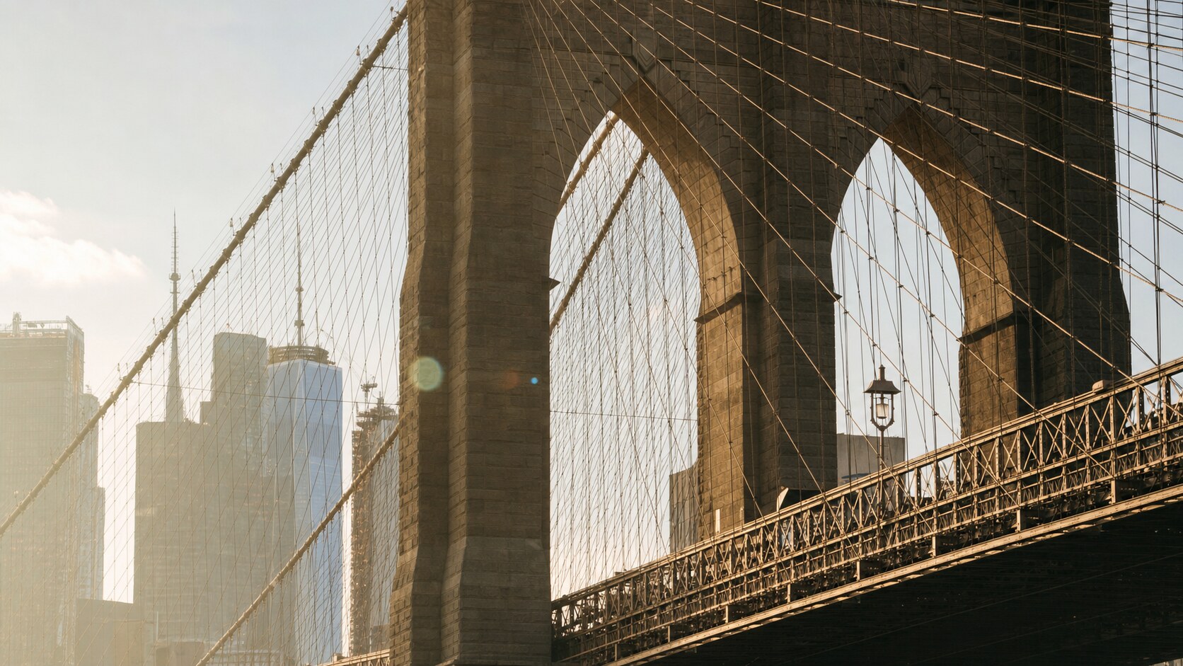 Close-up architectural detail of The Brooklyn Bridge at late afternoon, showing surface texture and material under directional sun
