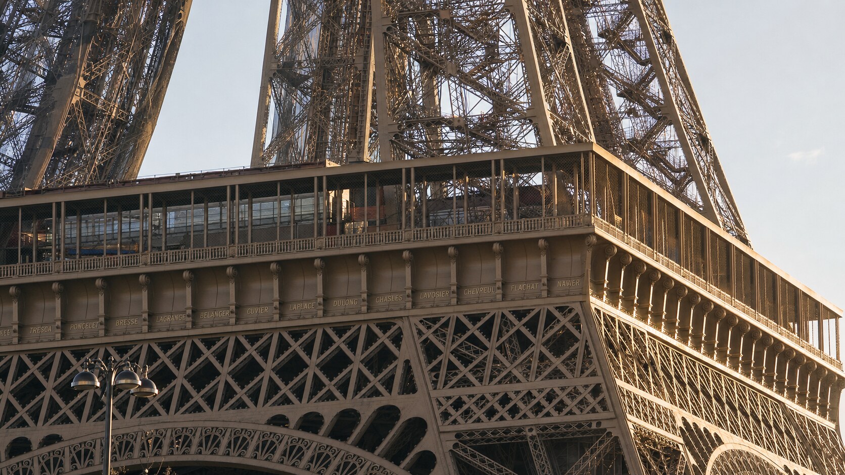 Close-up architectural detail of The Eiffel Tower Paris at late afternoon, showing surface texture and material under directional sun