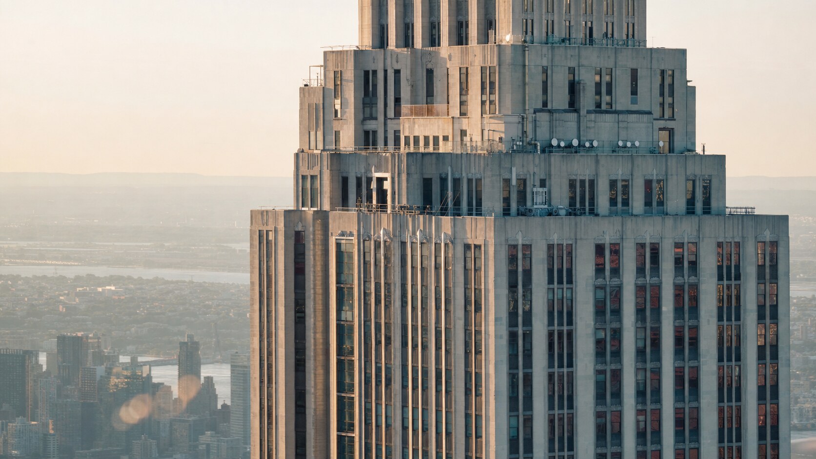 Close-up architectural detail of The Empire State Building at late afternoon, showing surface texture and material under directional sun