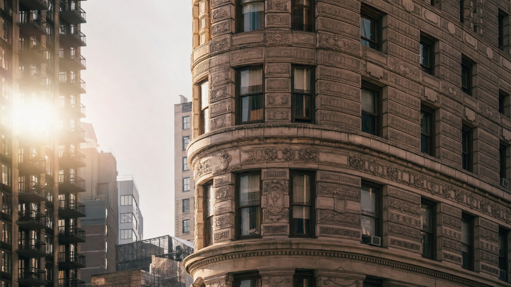 Close-up architectural detail of The Flatiron Building at late afternoon, showing surface texture and material under directional sun
