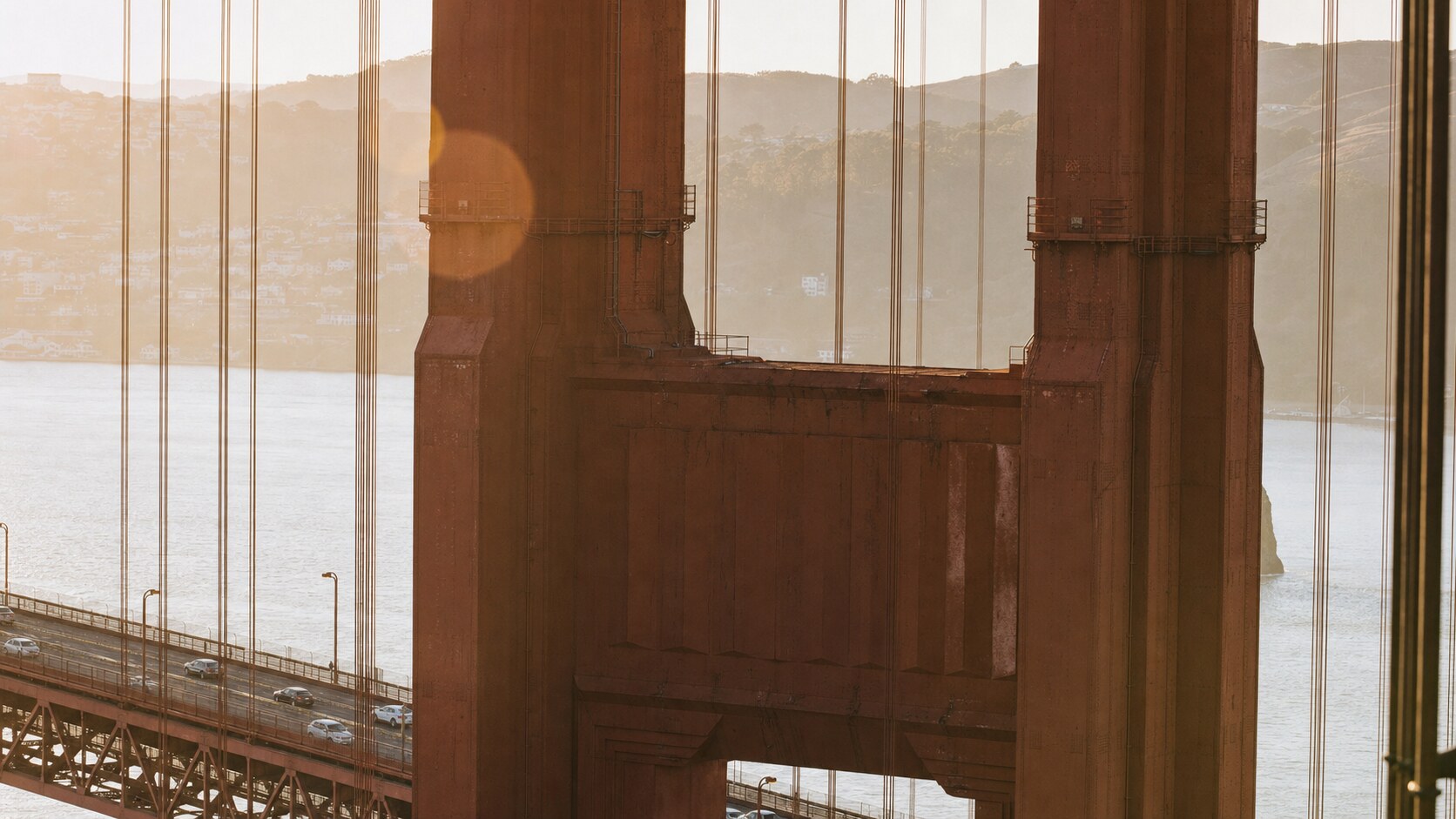 Close-up architectural detail of The Golden Gate Bridge at late afternoon, showing surface texture and material under directional sun