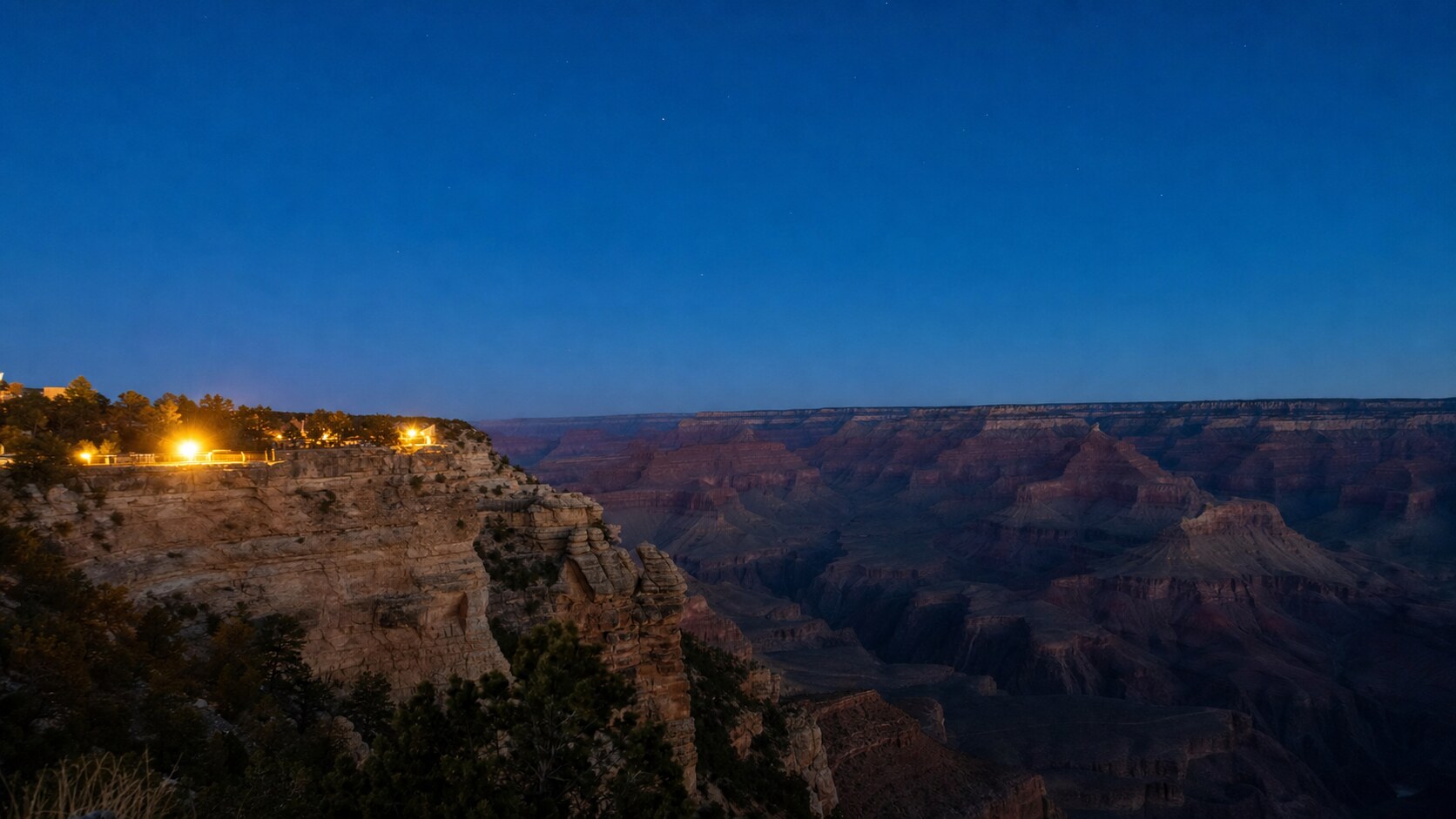 Wide blue-hour view of The Grand Canyon with cobalt sky and warm artificial lighting on the landmark