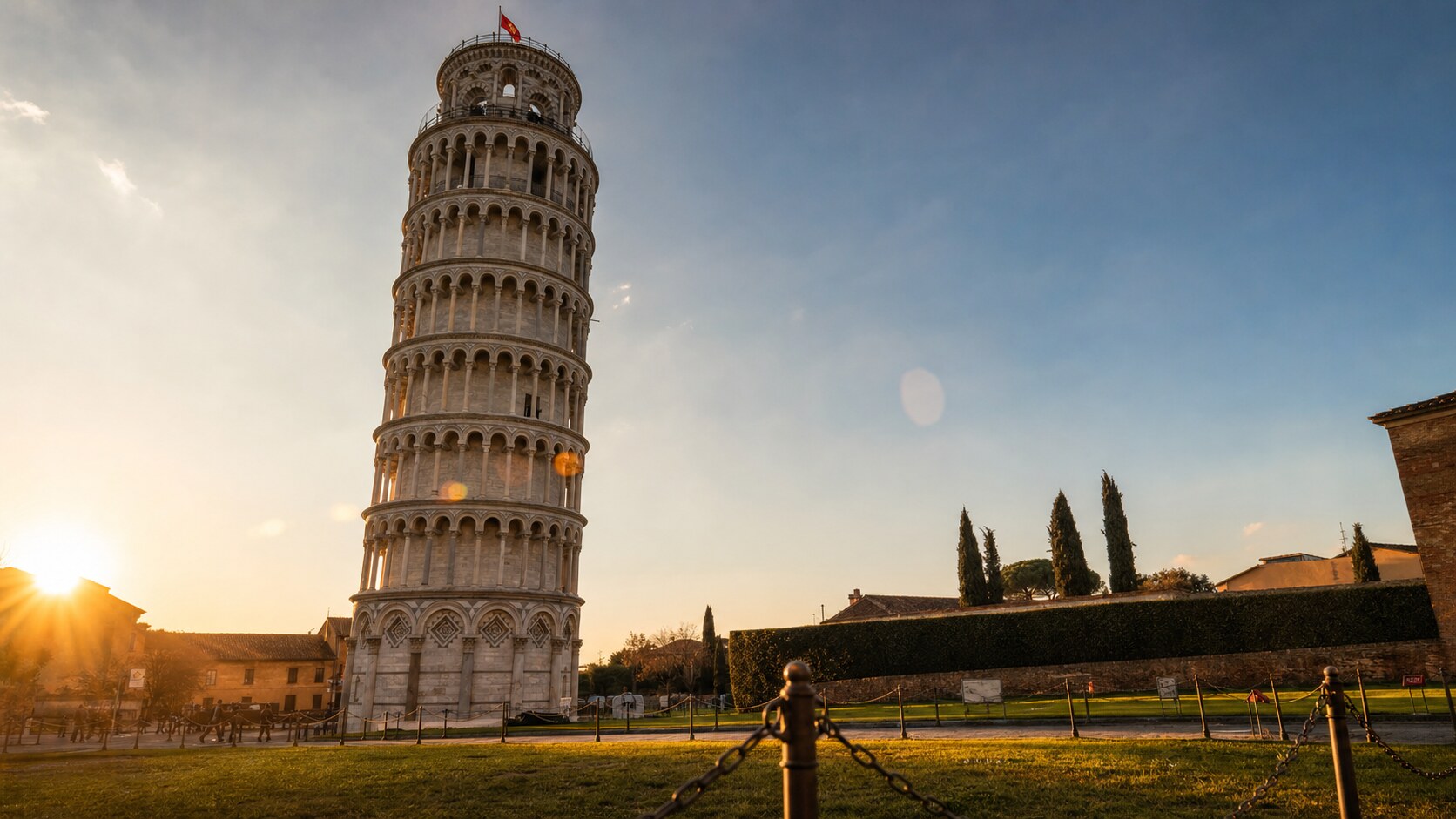 The Leaning Tower Of Pisa photographed at golden hour from the most popular hero-shot vantage point, with dramatic side-lighting on the structure