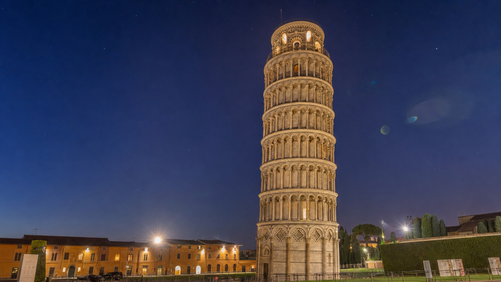 Wide blue-hour view of The Leaning Tower Of Pisa with cobalt sky and warm artificial lighting on the landmark