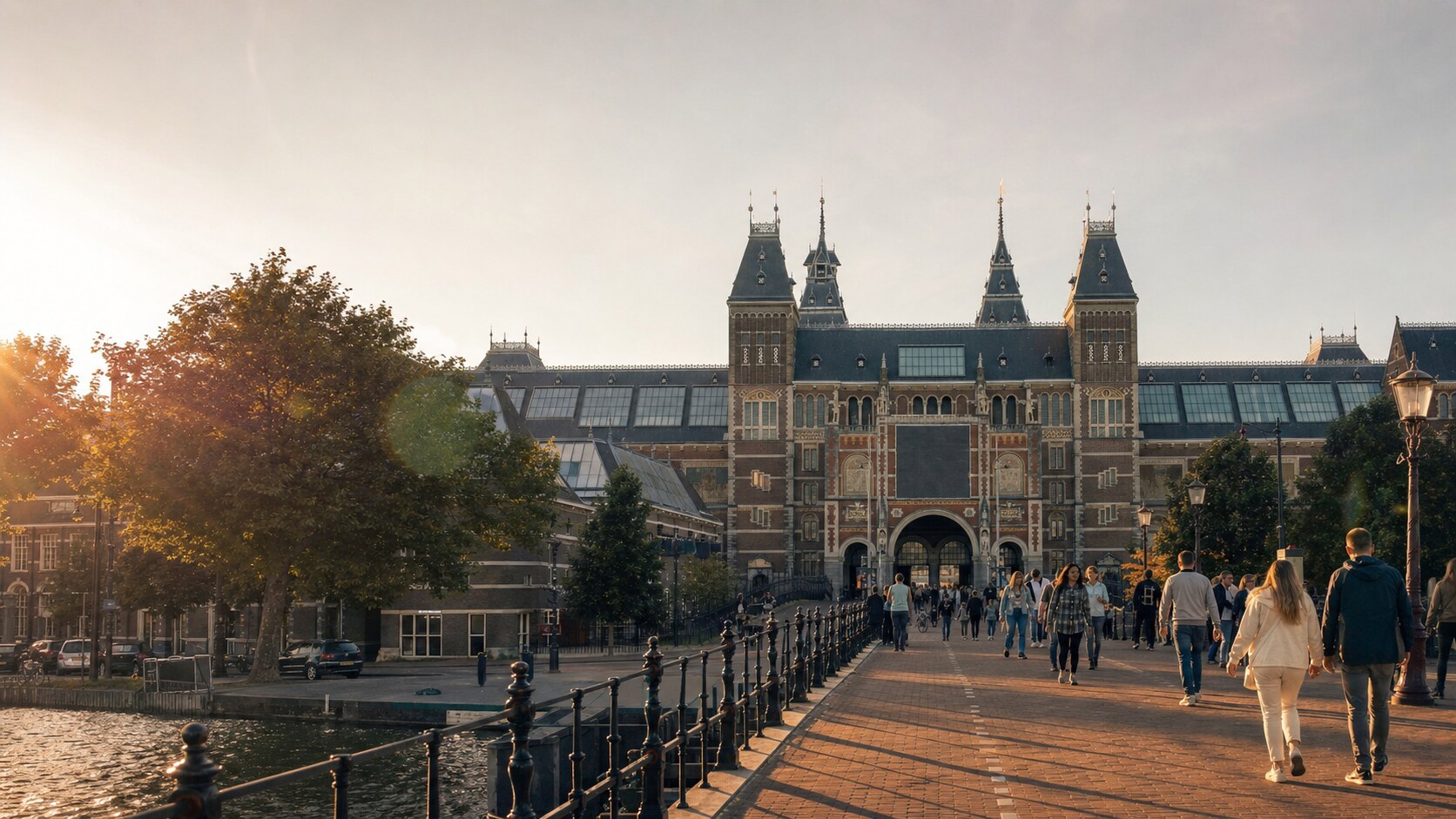 The Rijksmuseum photographed at golden hour from the most popular hero-shot vantage point, with dramatic side-lighting on the structure