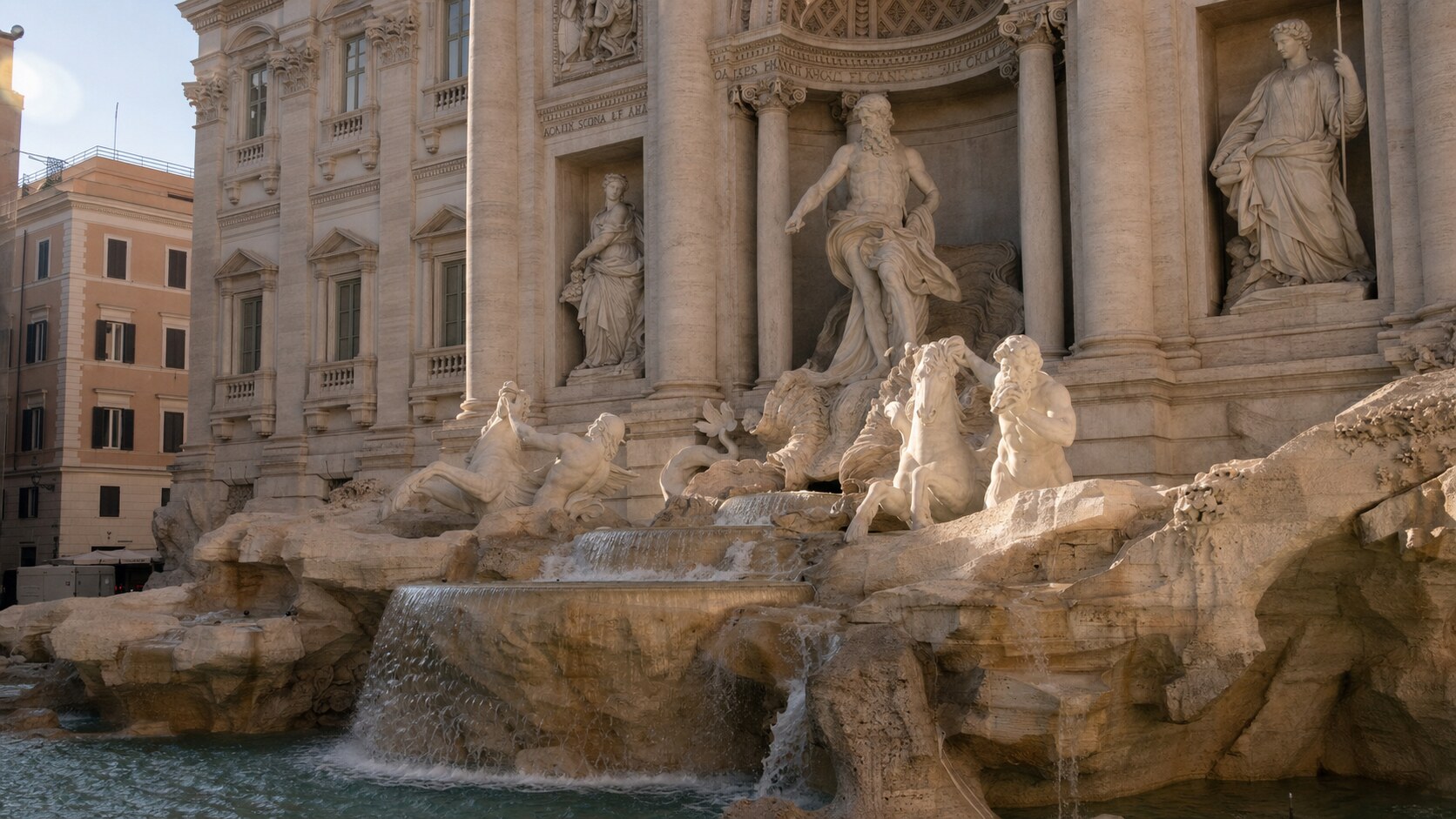 Close-up architectural detail of The Trevi Fountain Rome at late afternoon, showing surface texture and material under directional sun
