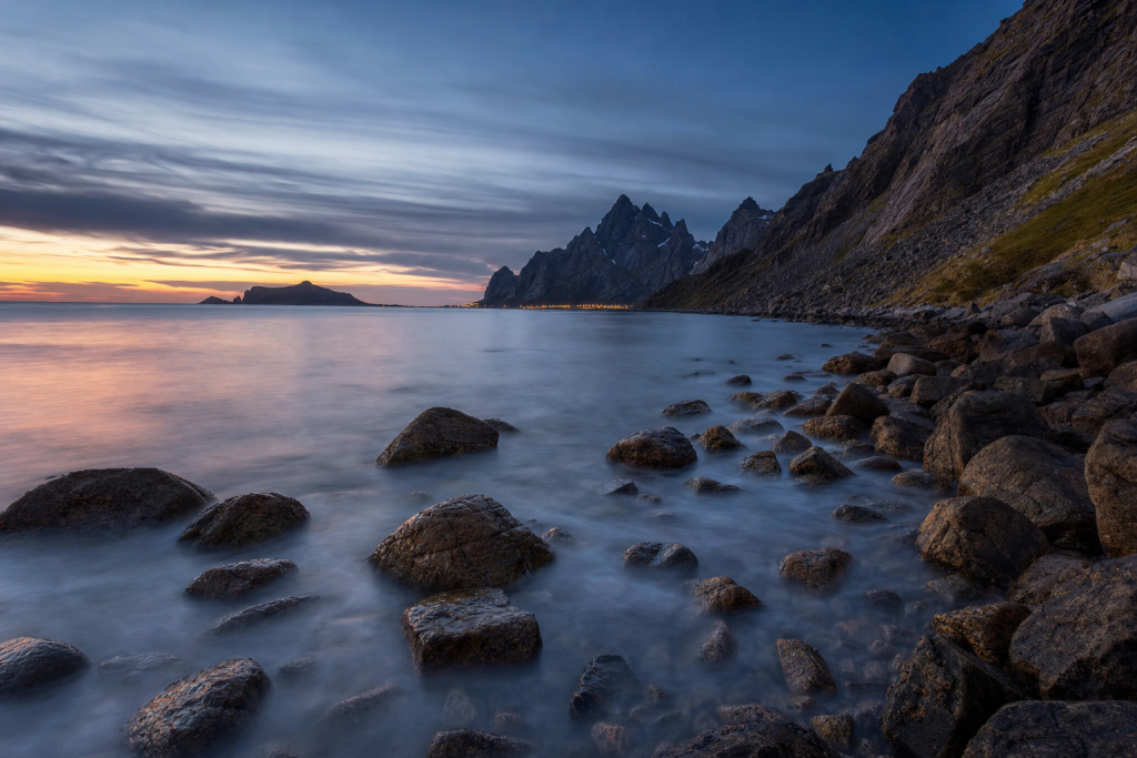 Long-exposure coastal landscape at blue hour, silky water, dramatic sky
