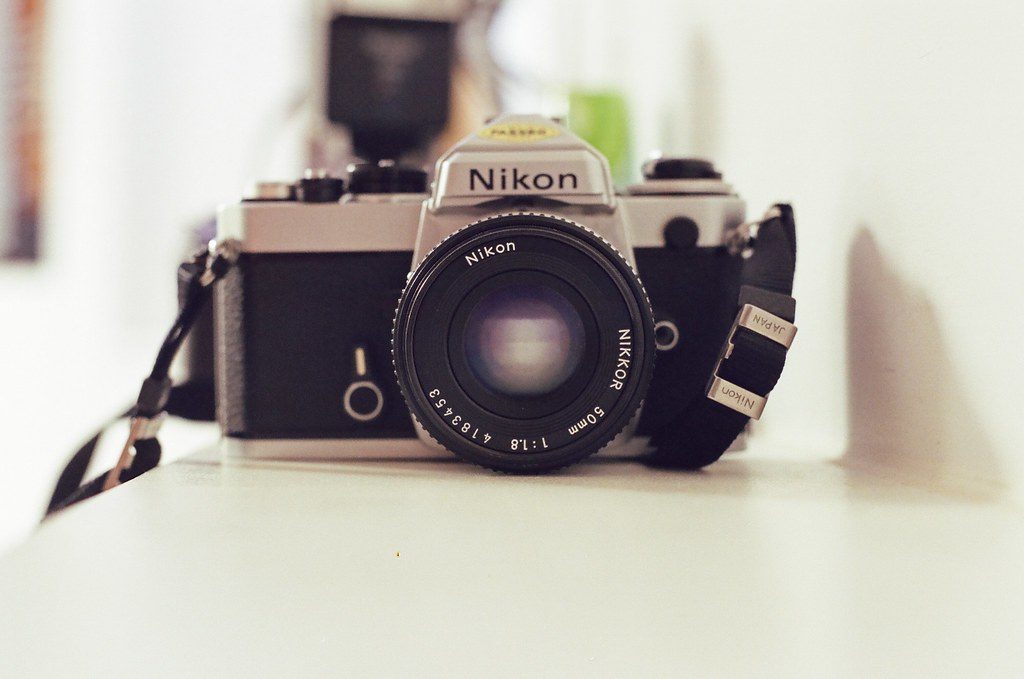 Detailed product photo of the Rewindpix retro digital film camera in hand, showing the compact shape, shutter button,