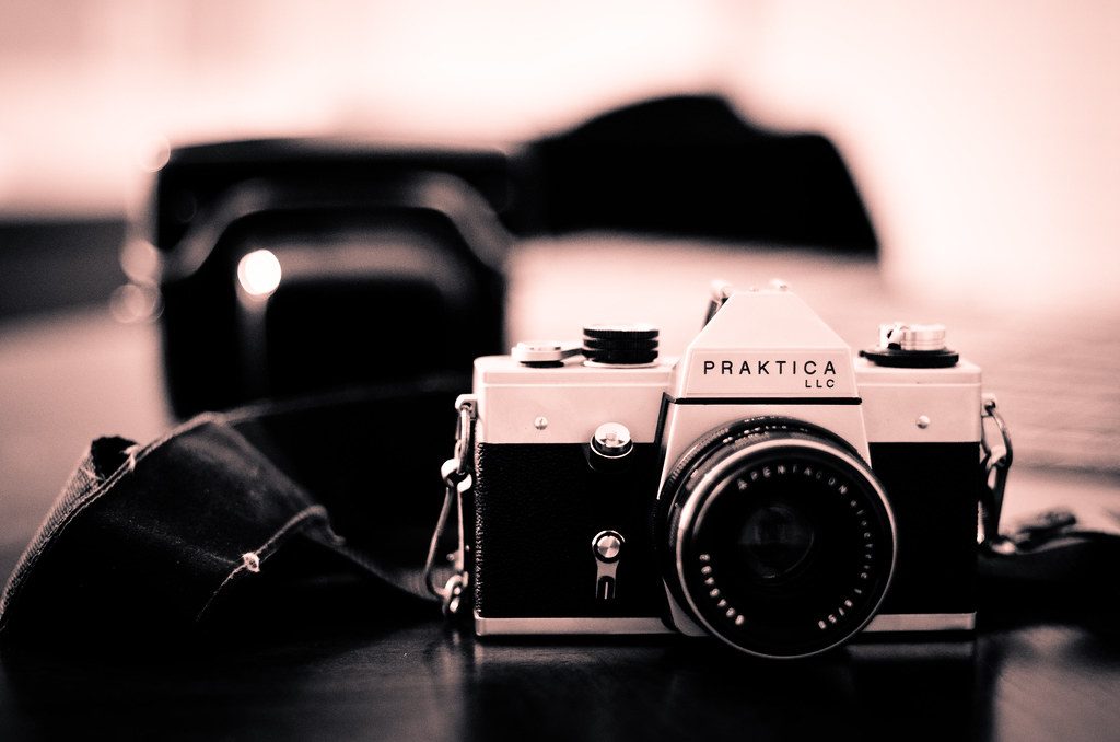 Vintage medium-format film camera and canisters, highlighting trends in current photography tutorials.