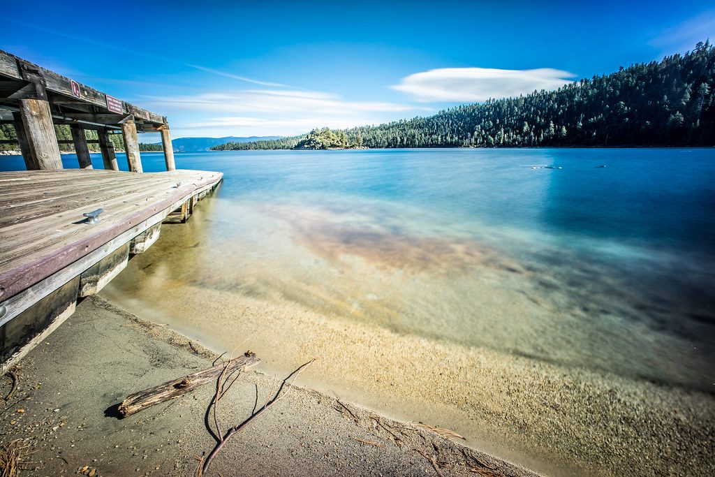 Alpine lake landscape with driftwood foreground to avoid landscape photography mistakes in composition.