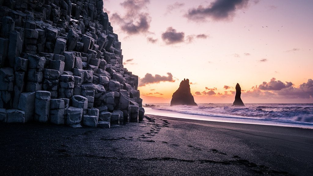 Travel photographer capturing ethereal landscapes from a misty mountain peak during a sunrise shoot.