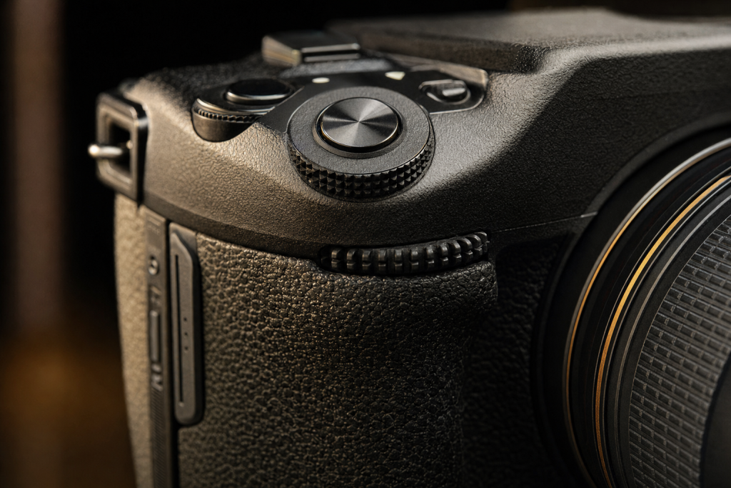 Detail shot of camera controls and grip, dramatic side lighting, macro feel, no text