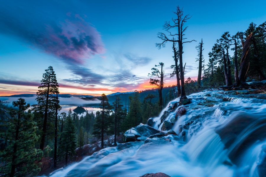 Eagle Falls flowing above Emerald Bay, Lake Tahoe, beneath a colorful sunrise sky