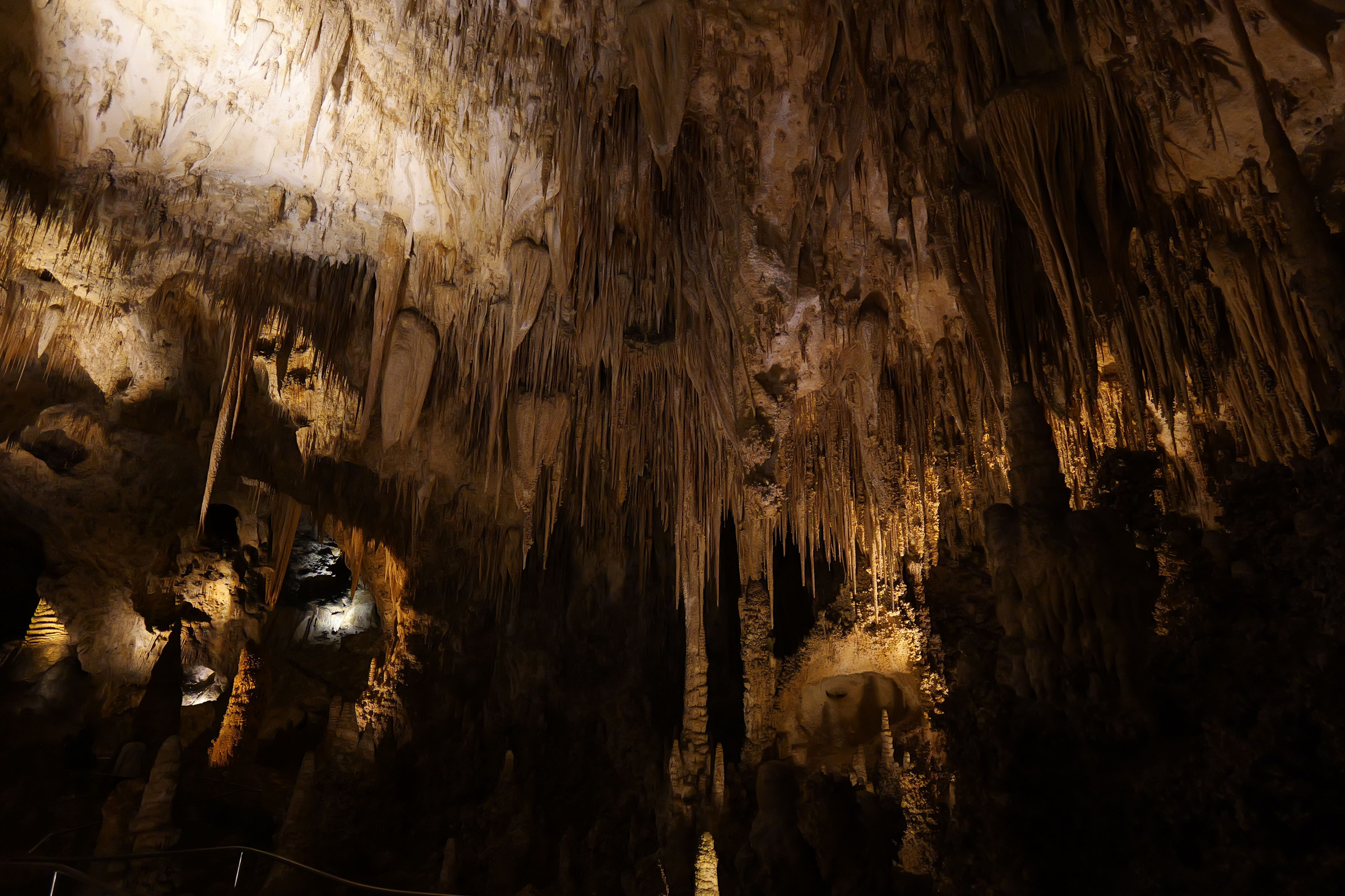 Layers of illuminated cave formations against dark recesses at Carlsbad Caverns