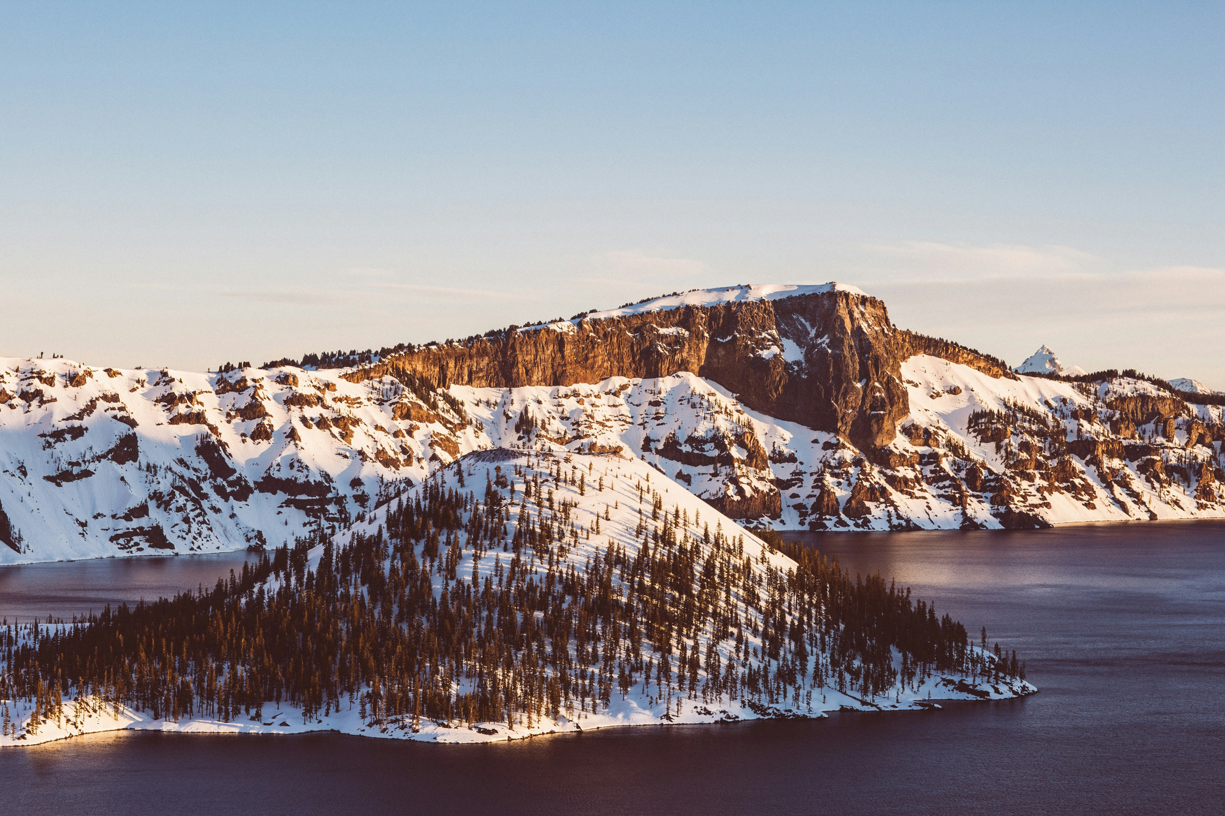 Snow on Wizard Island and the Crater Lake caldera wall