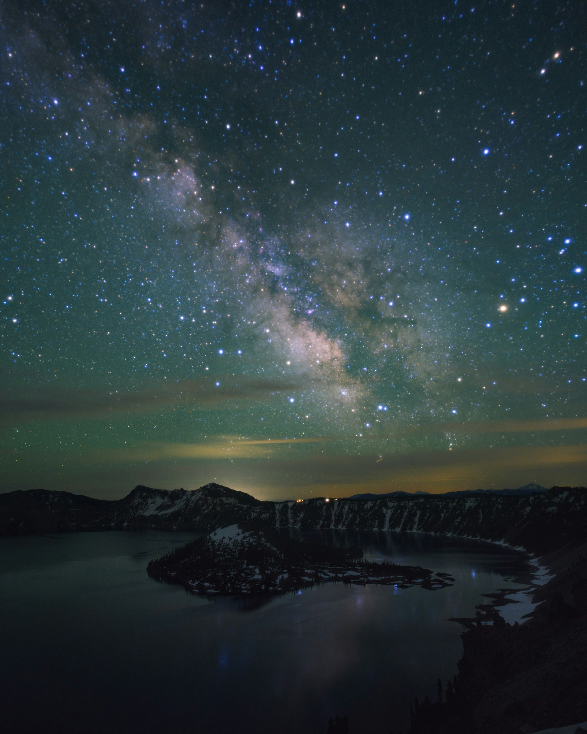 Milky Way above snow-covered Wizard Island and Crater Lake at night