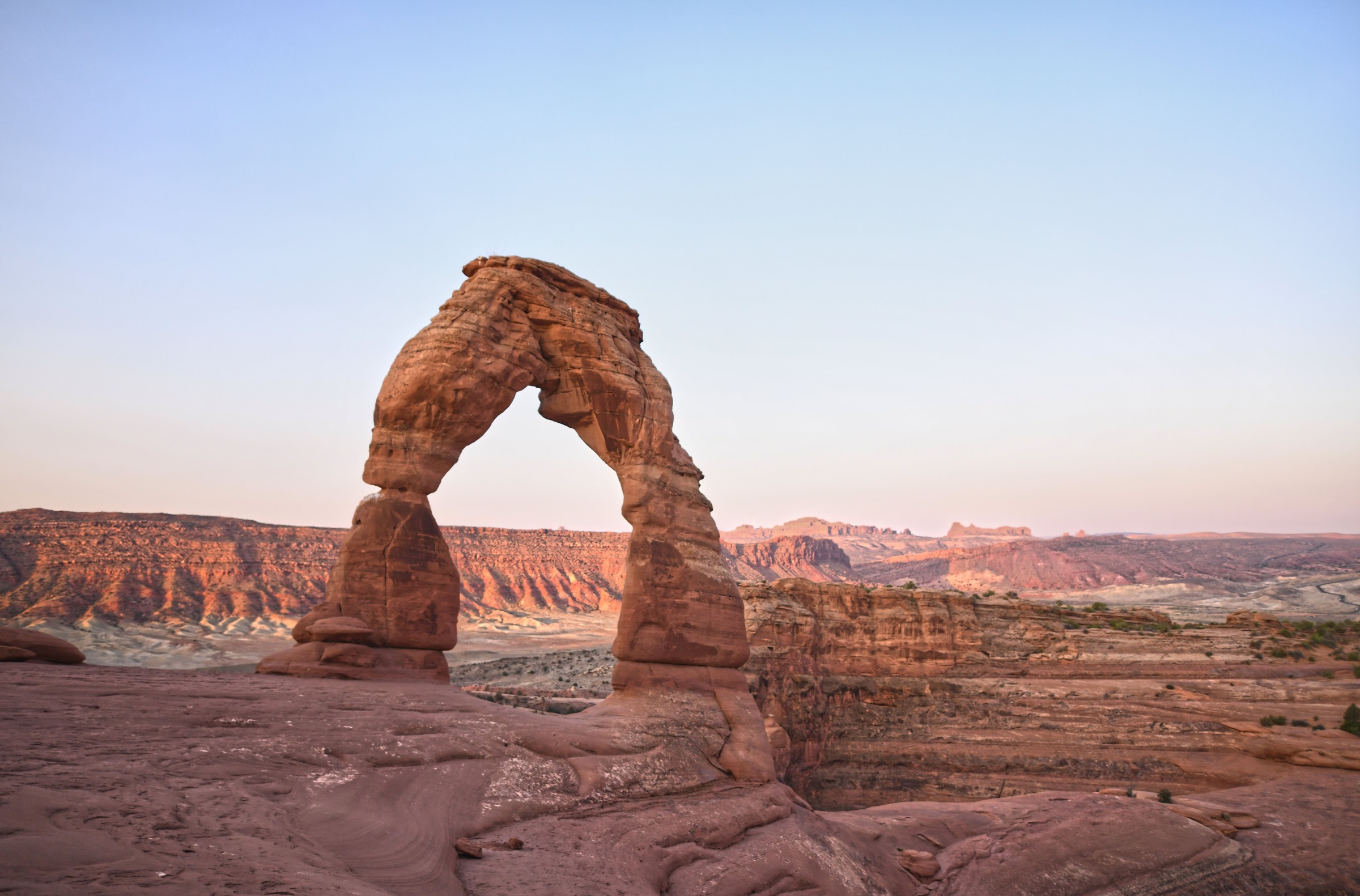 Delicate Arch in a horizontal frame above a sandstone foreground