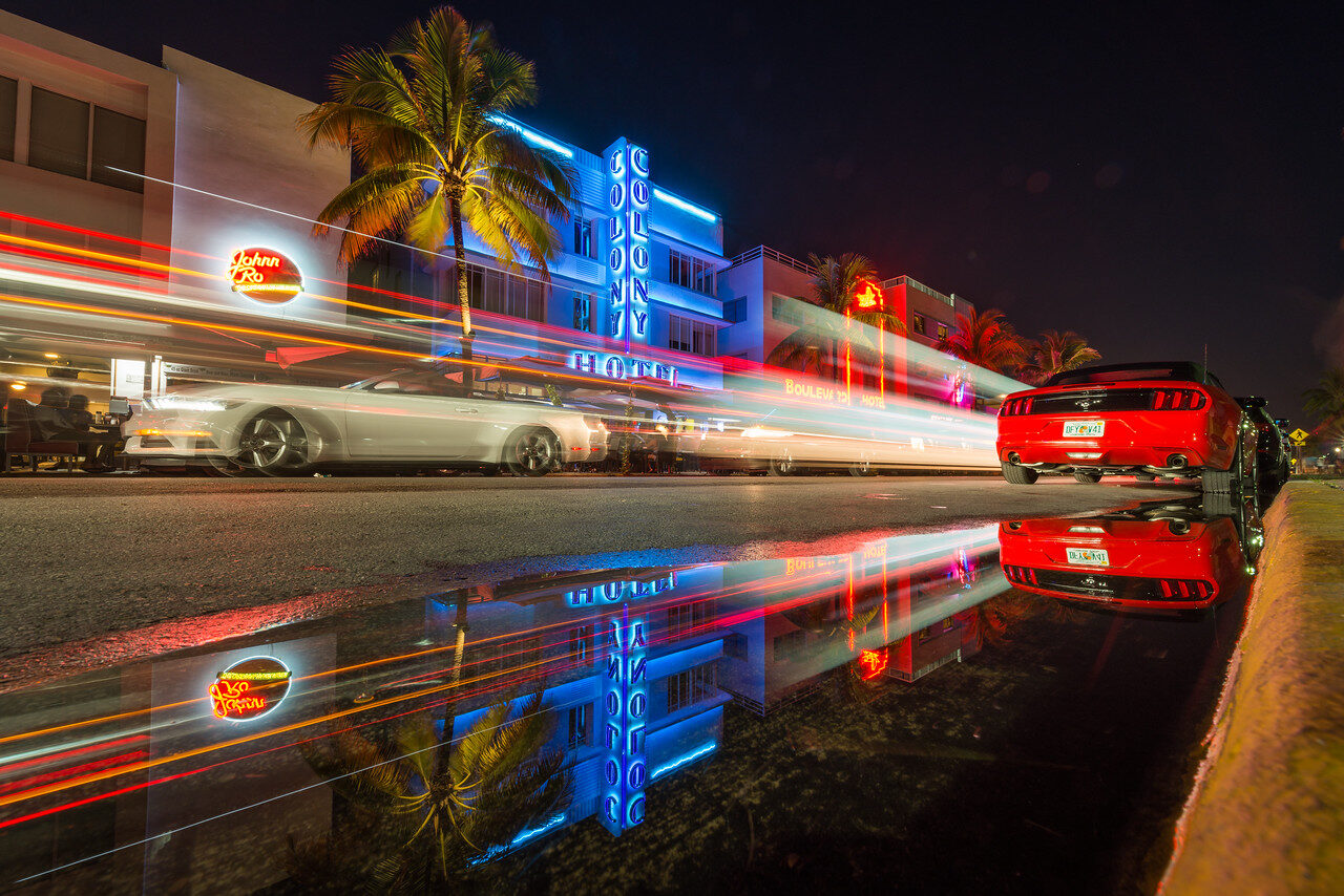 Ocean Drive neon and traffic trails reflected in a puddle