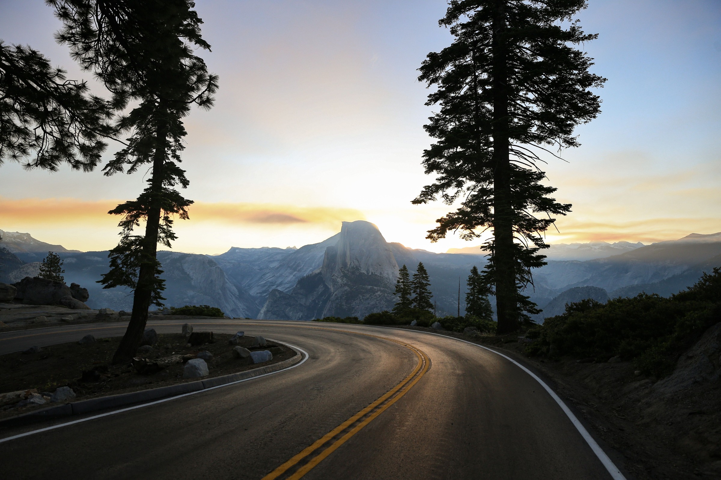 Glacier Point Road curving below trees with Half Dome beyond