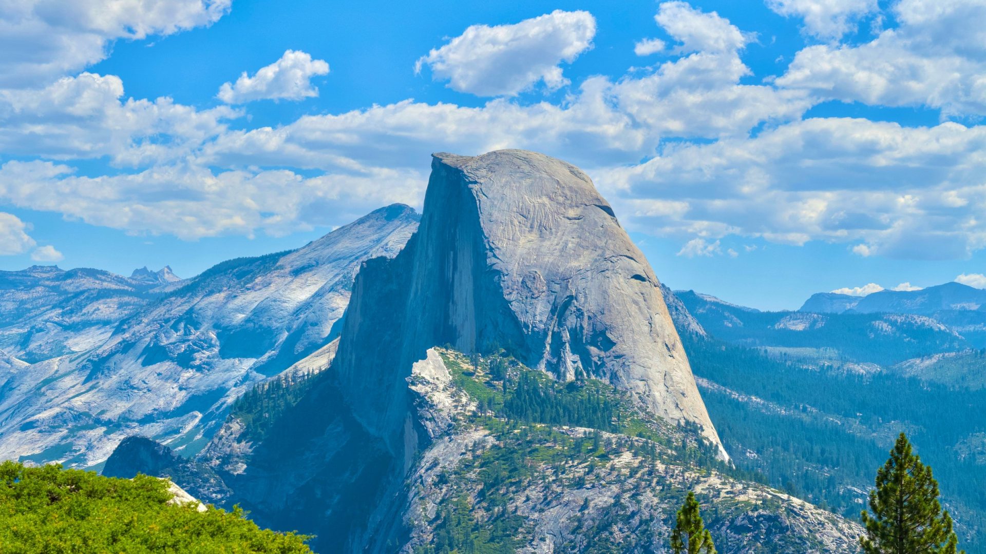 Half Dome framed by green foreground and clouds from Glacier Point