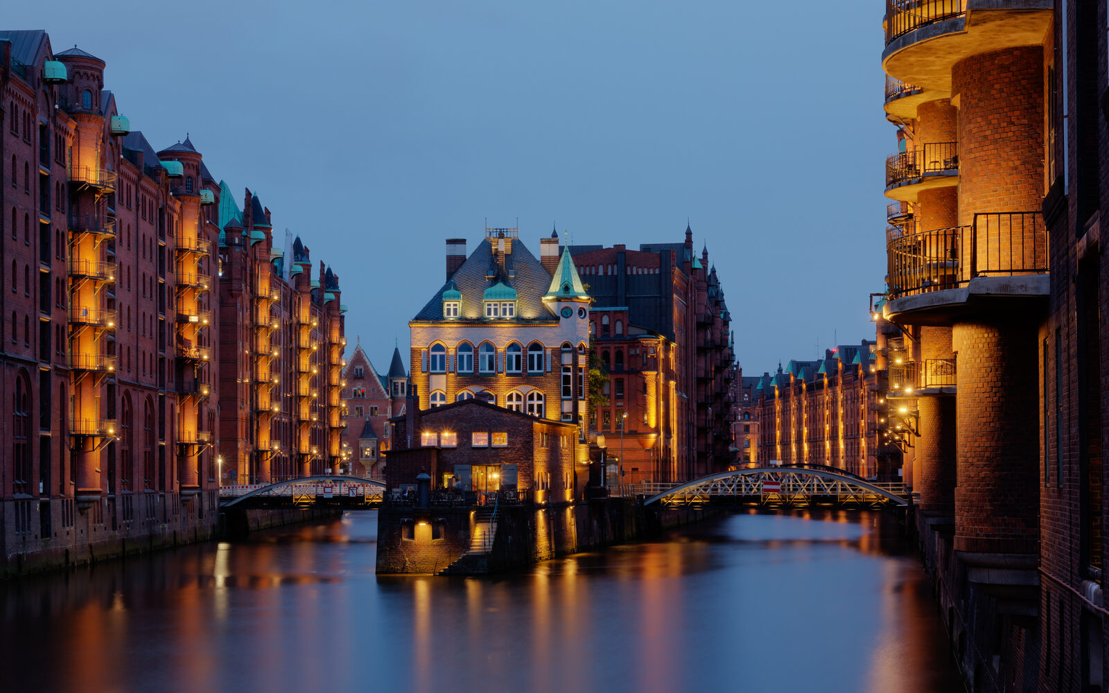 Hamburg Speicherstadt warehouse district at night with reflections on canal and warm tungsten window light