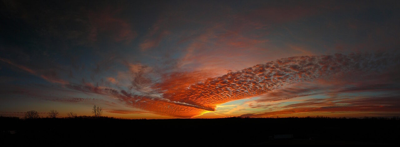 Tennessee sunset panorama with orange and pink sky over silhouetted rolling hills and tree line