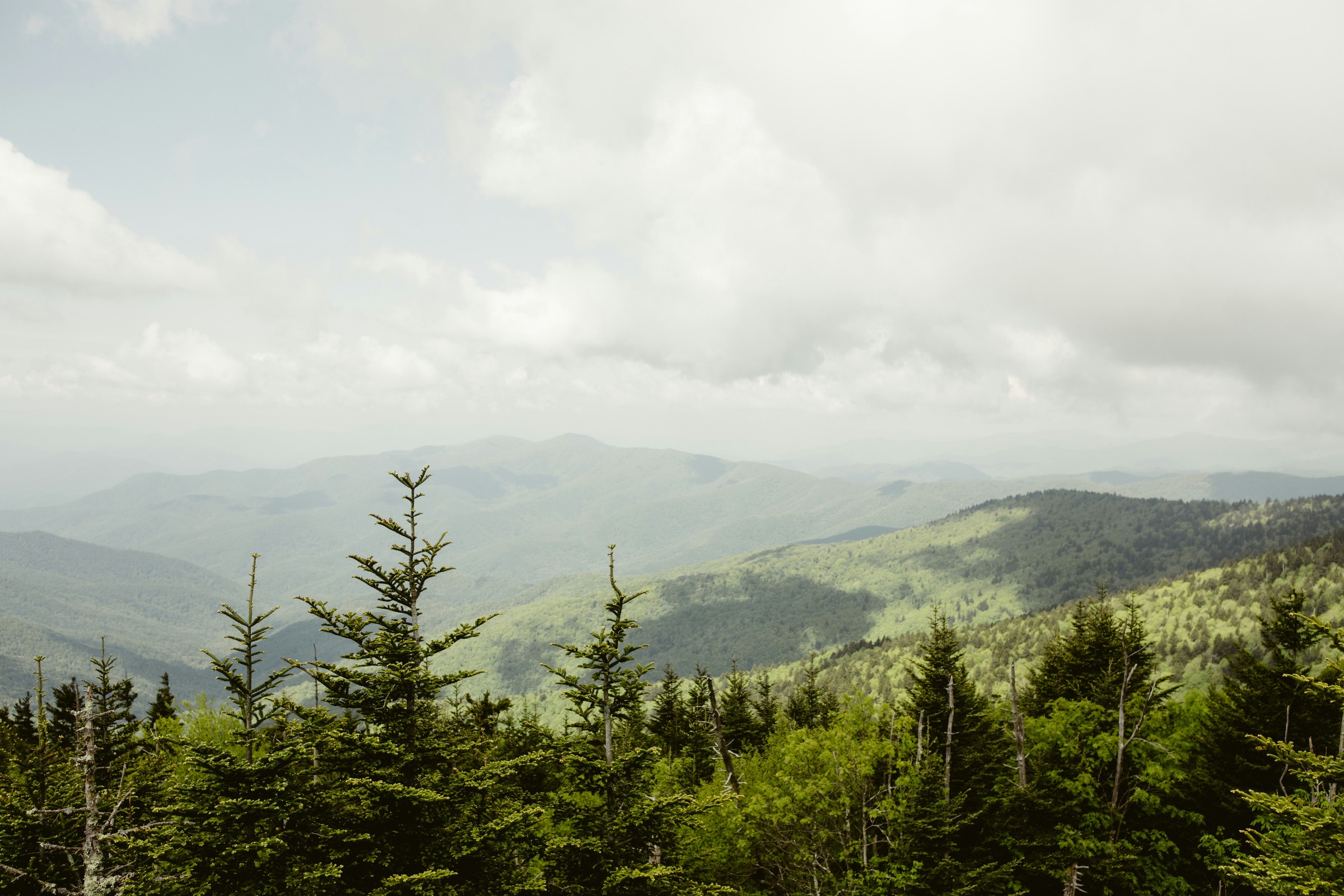 Green mountain ridges and hazy layers viewed from the top of Kuwohi