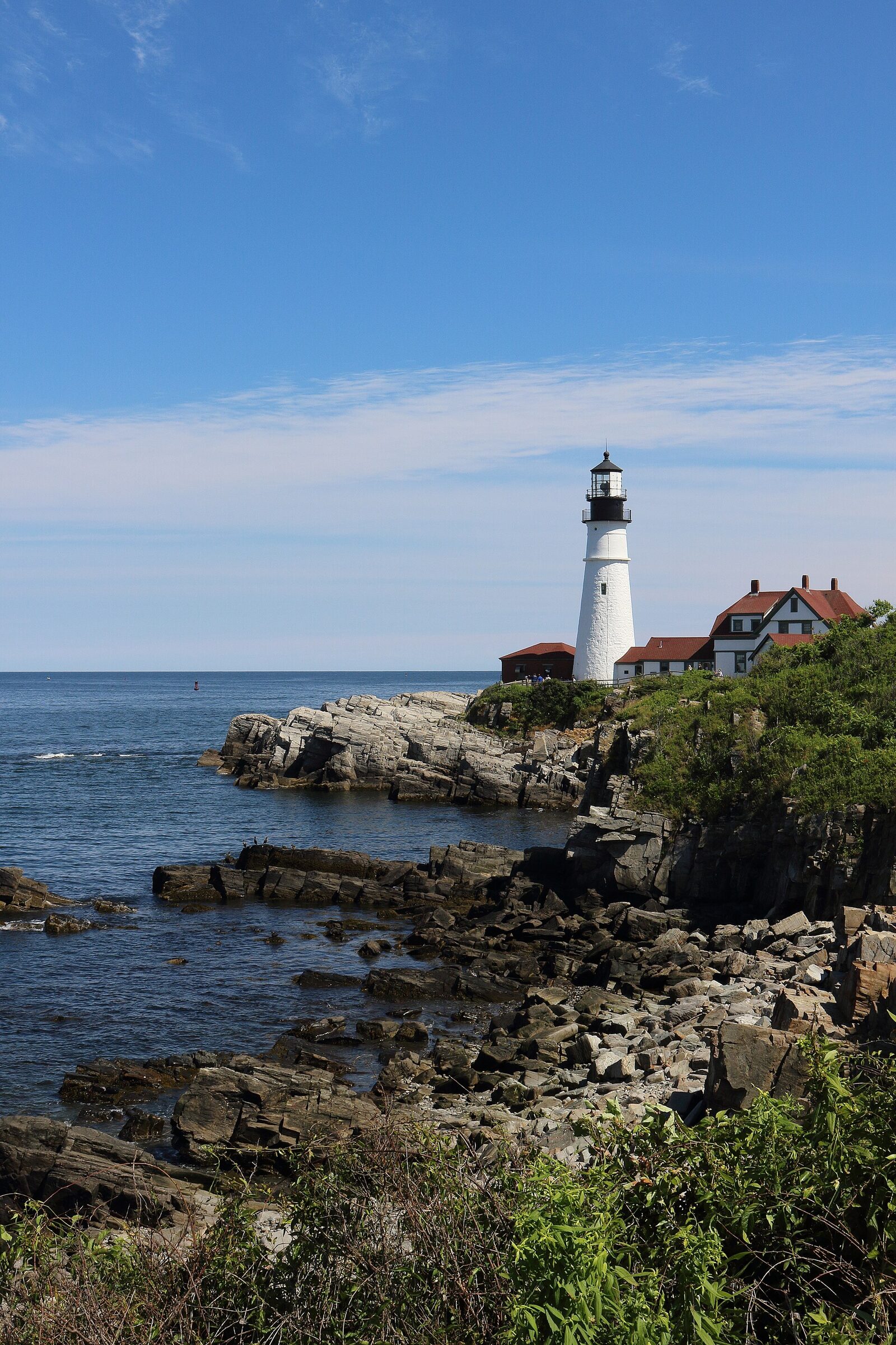 Wide composition of Portland Head Light at Cape Elizabeth in Portland, Maine demonstrating a travel photography composition.
