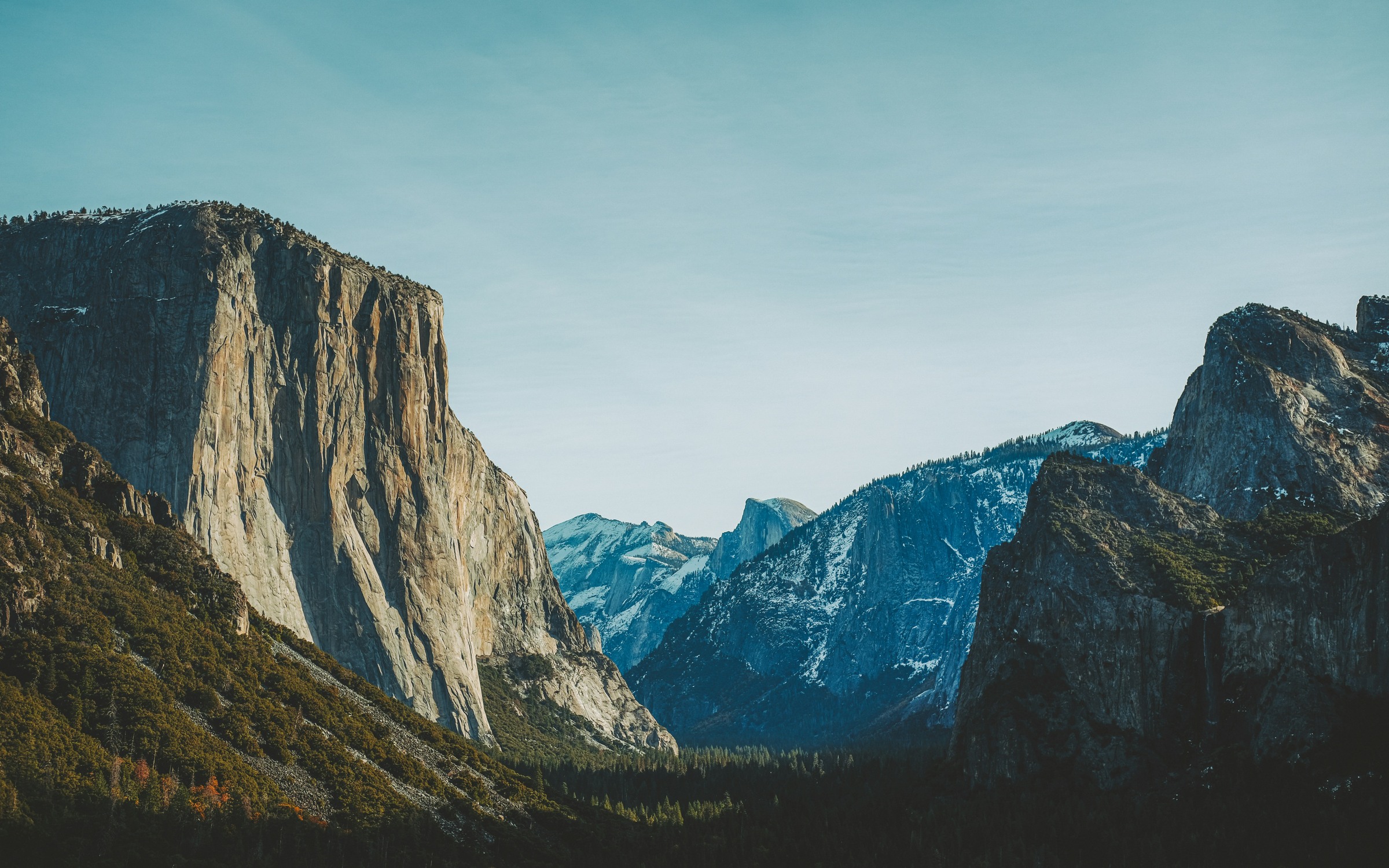 Snow on distant Yosemite rock with sunlit El Capitan at Tunnel View