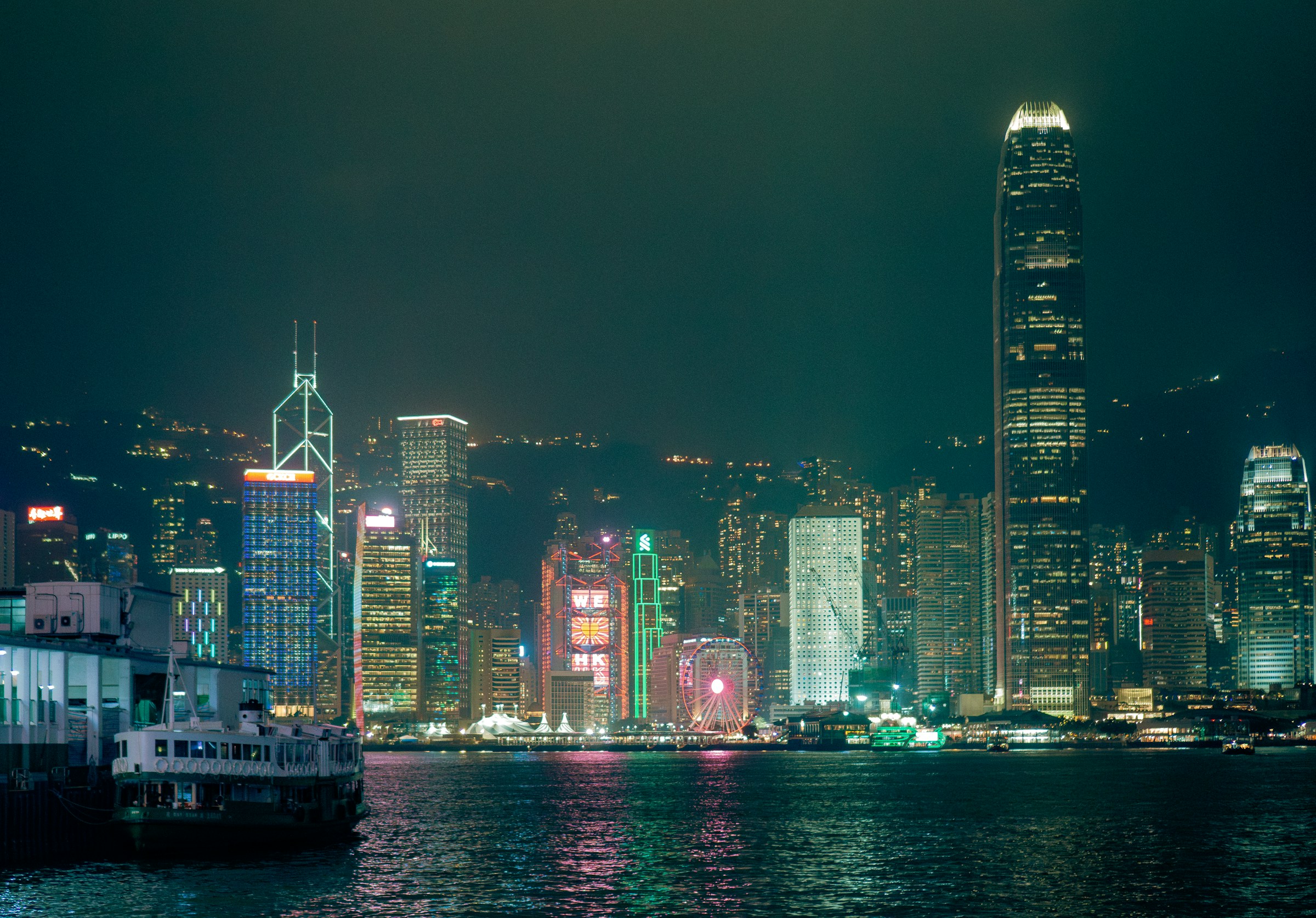 Star Ferry crossing Victoria Harbour in front of the Hong Kong Island skyline at night