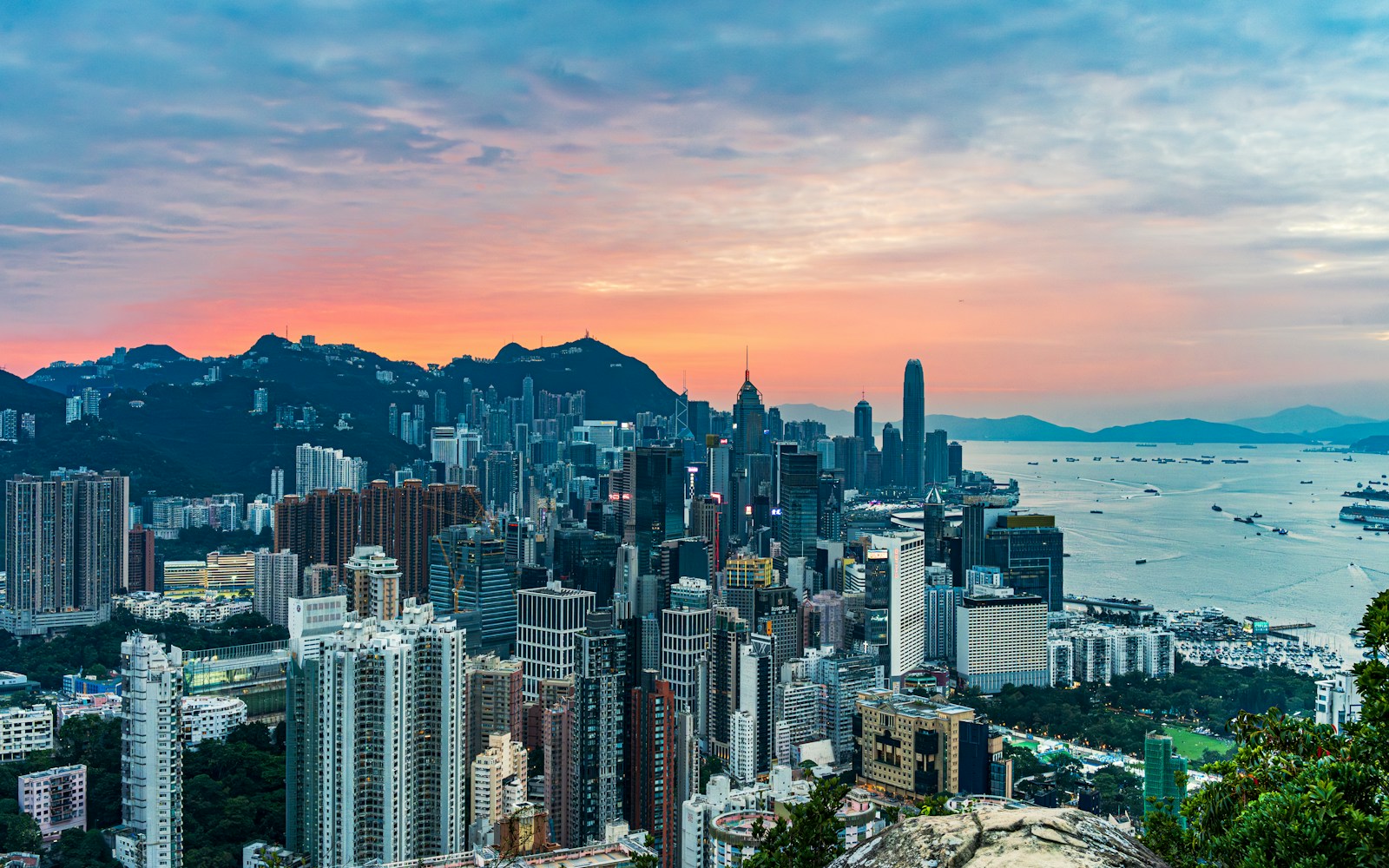 Hong Kong skyline and Victoria Harbour under a pink-orange sunset from Braemar Hill