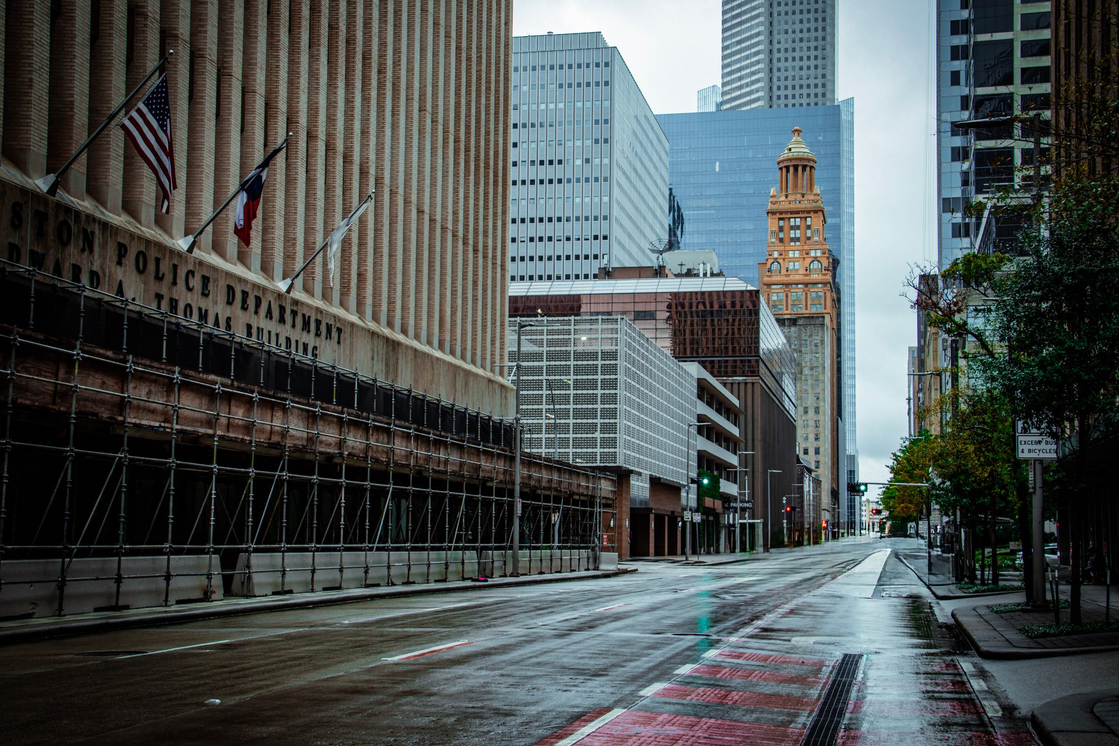Rain-wet downtown Houston street with historic tower in the distance