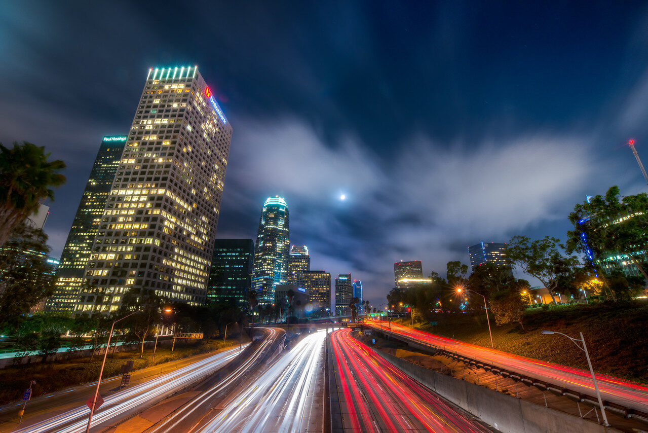 Downtown Los Angeles skyline and freeway light trails at blue hour