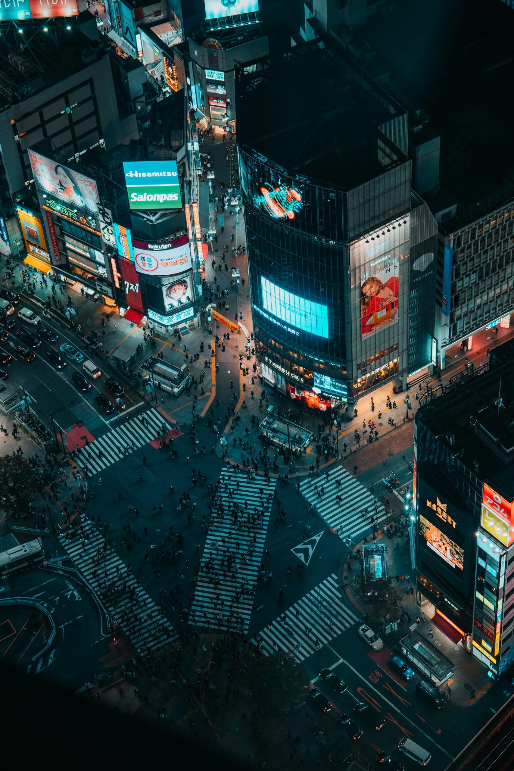 Shibuya Crossing in Tokyo at night with neon lights and pedestrians