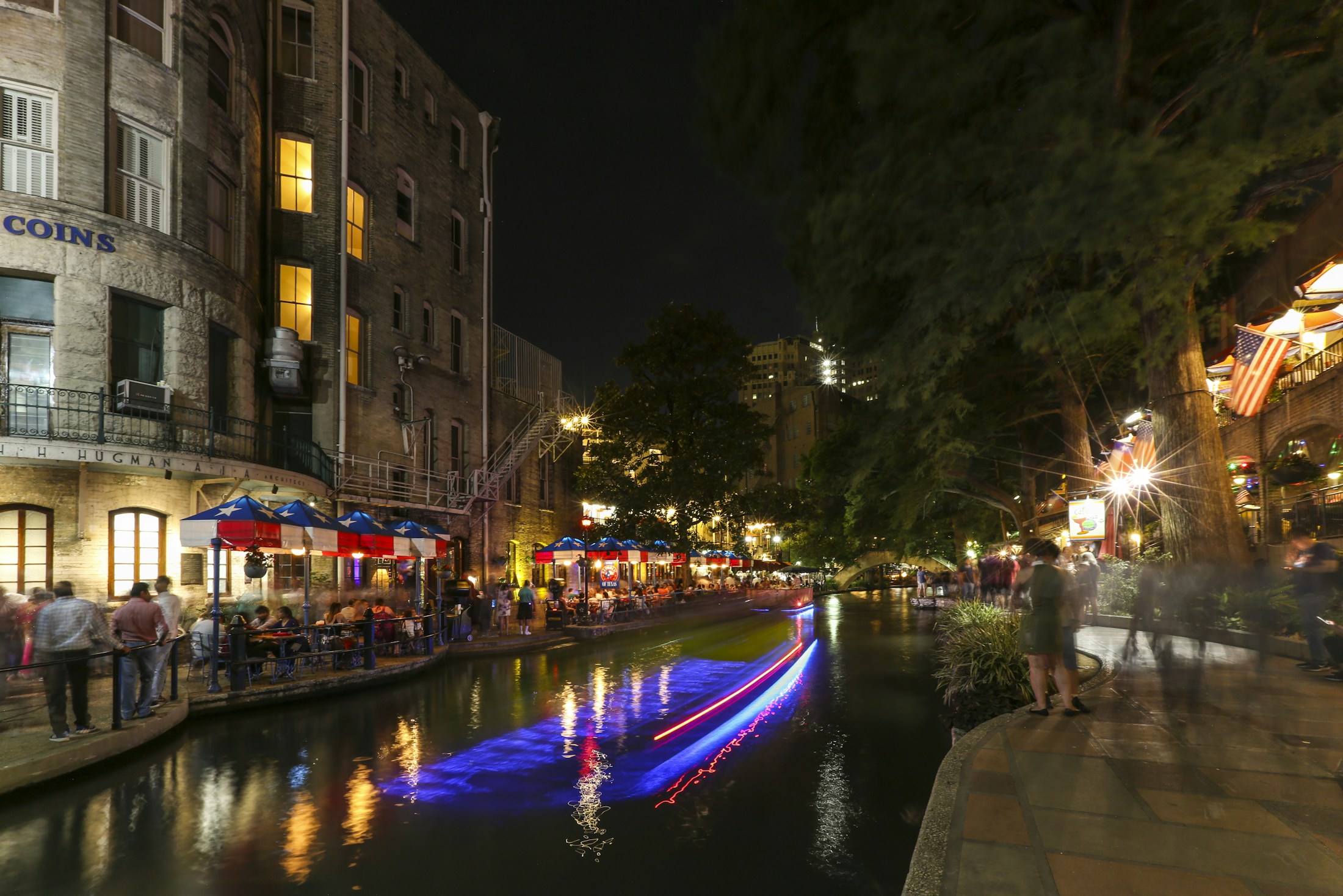 Boat light trails and reflections on the San Antonio River Walk at night