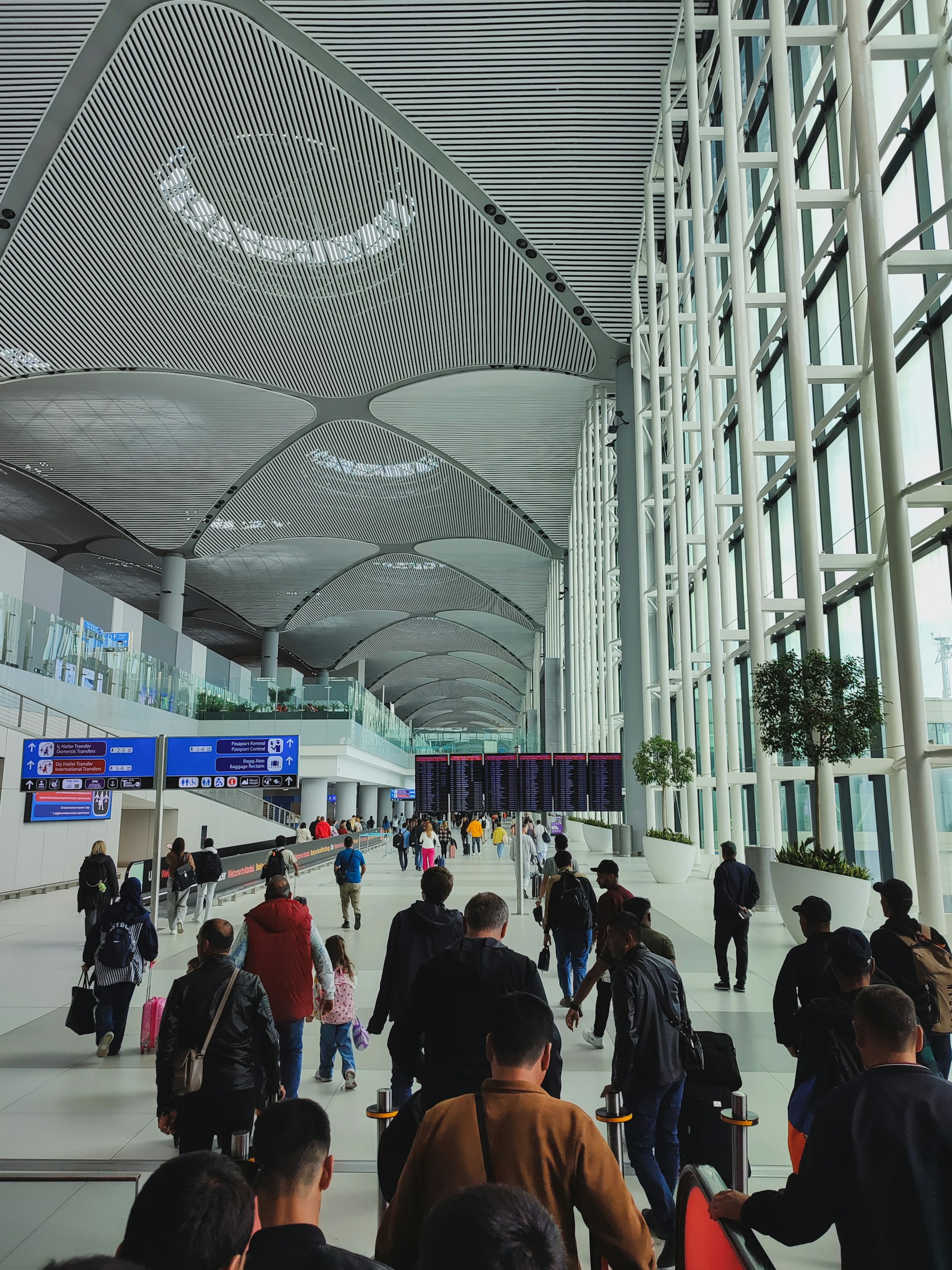 Travelers beneath vaulted Istanbul Airport terminal roof