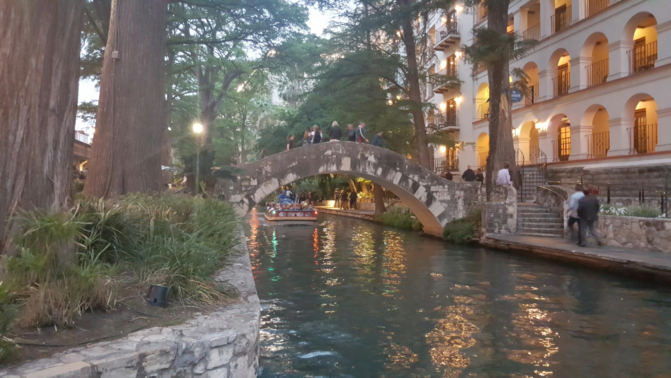 Stone bridge over San Antonio River Walk at dusk