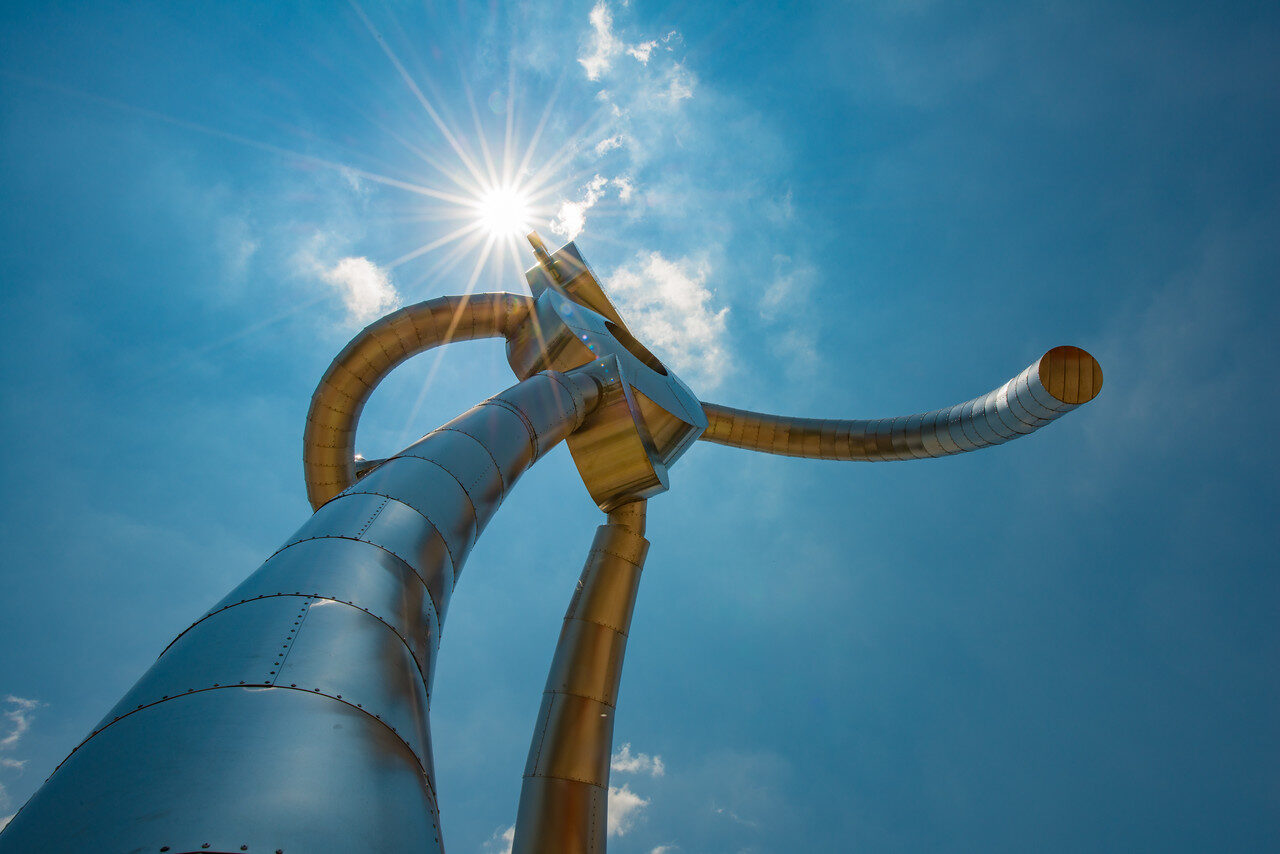 The Traveling Man sculpture under a sunburst in Dallas