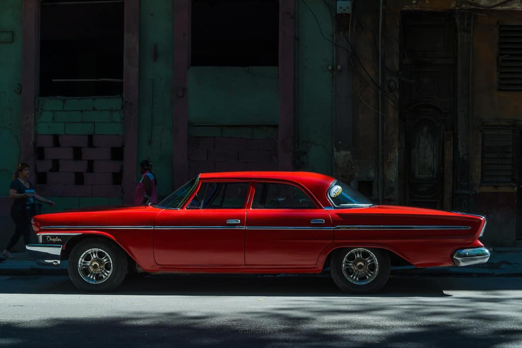 Street Photography Camera Settings - red vintage car in a shaft of light in Havana, photographed by Edin Chavez