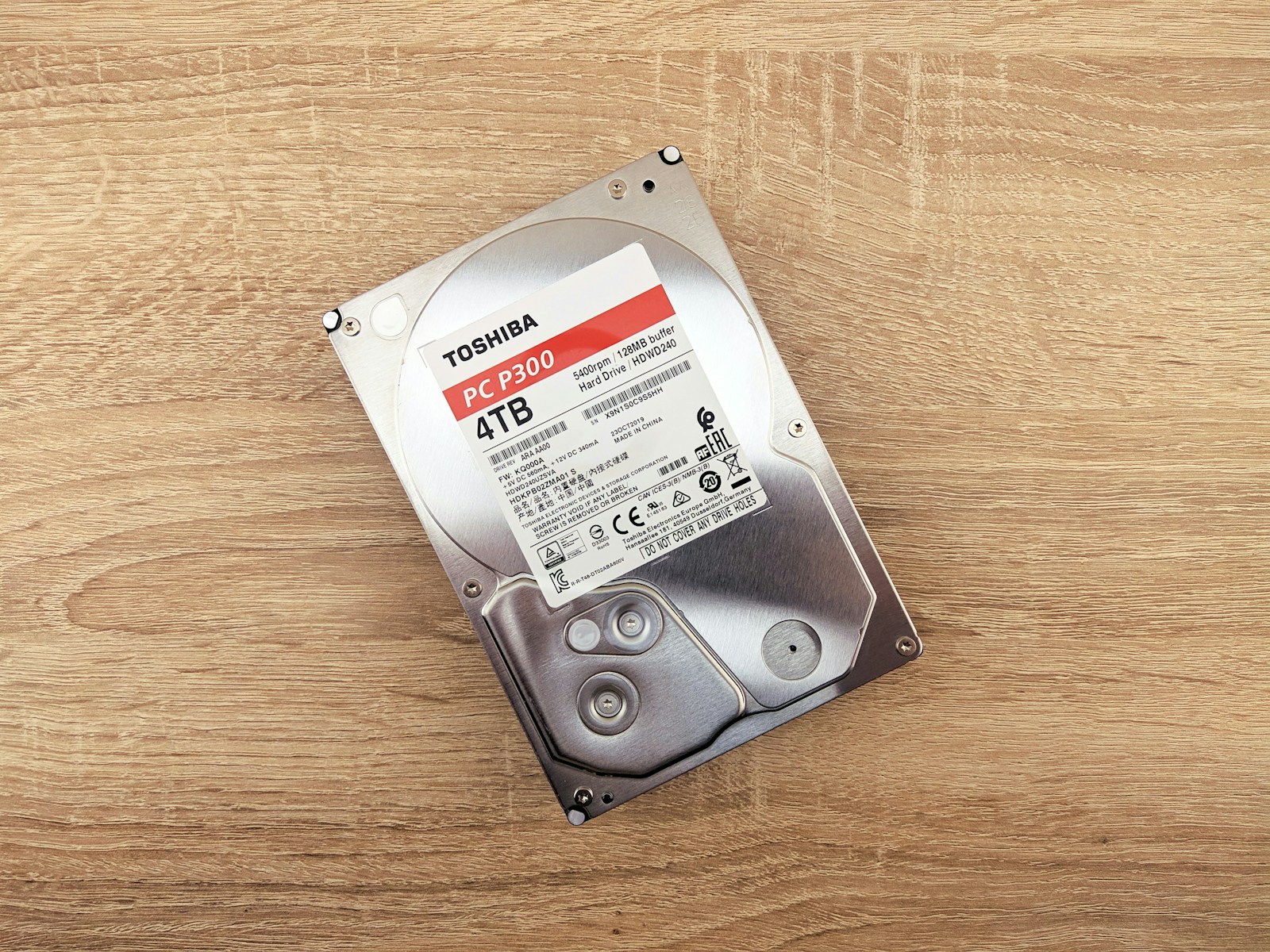 A Toshiba 4TB internal hard drive resting on a wooden tabletop