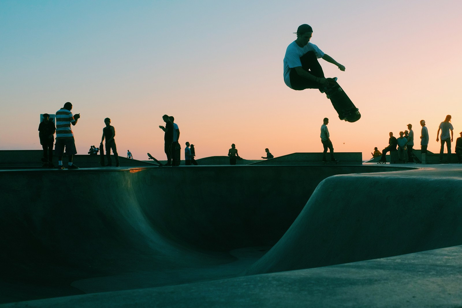 Skateboarder airborne at Venice Beach skatepark at sunset