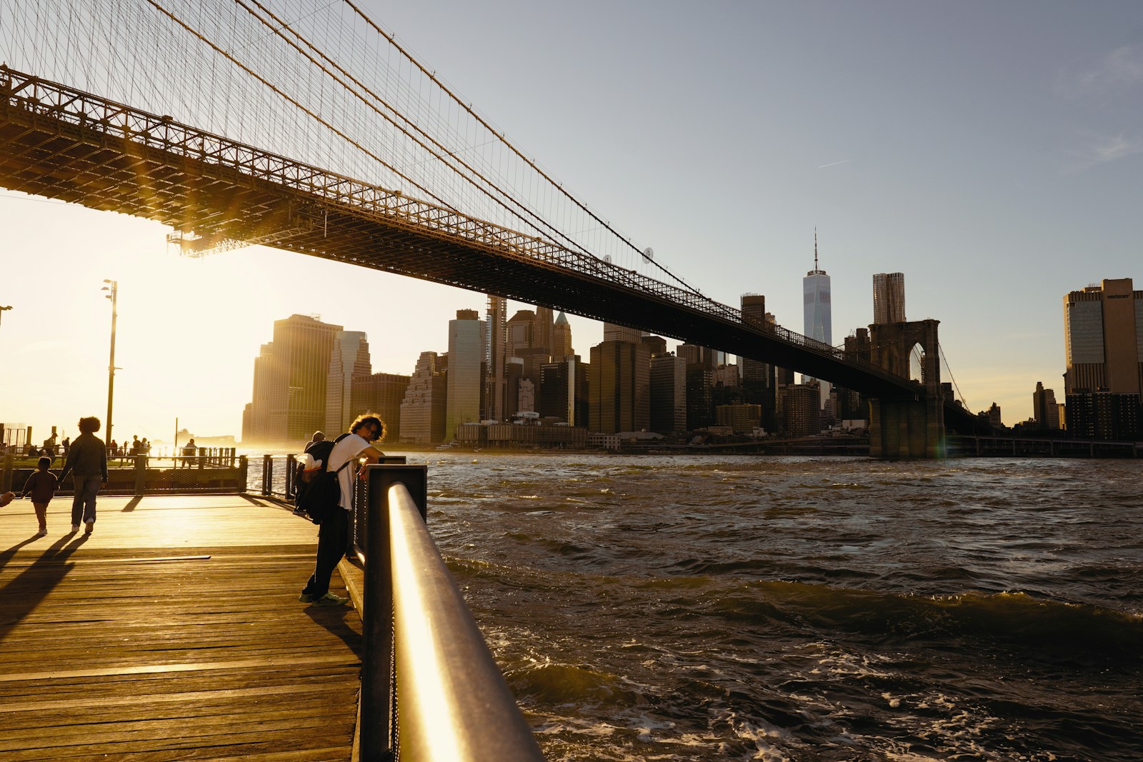 Brooklyn Bridge and Lower Manhattan skyline in late golden light from the waterfront