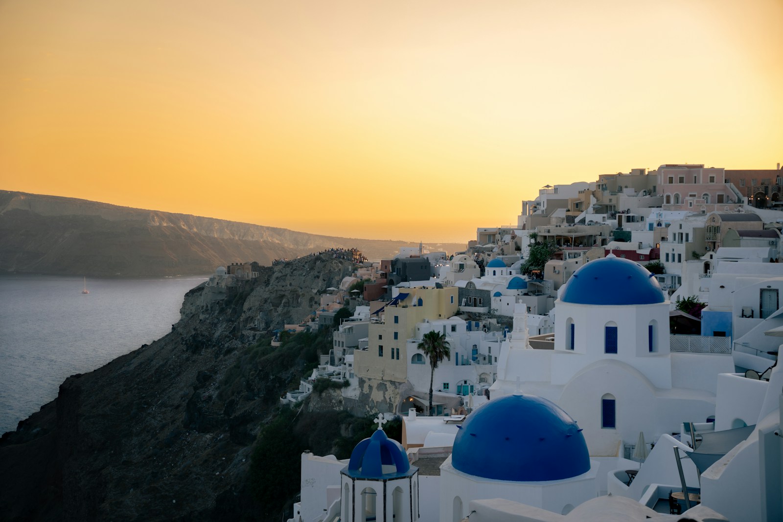 Blue-domed churches in Oia overlooking the Santorini caldera at sunset
