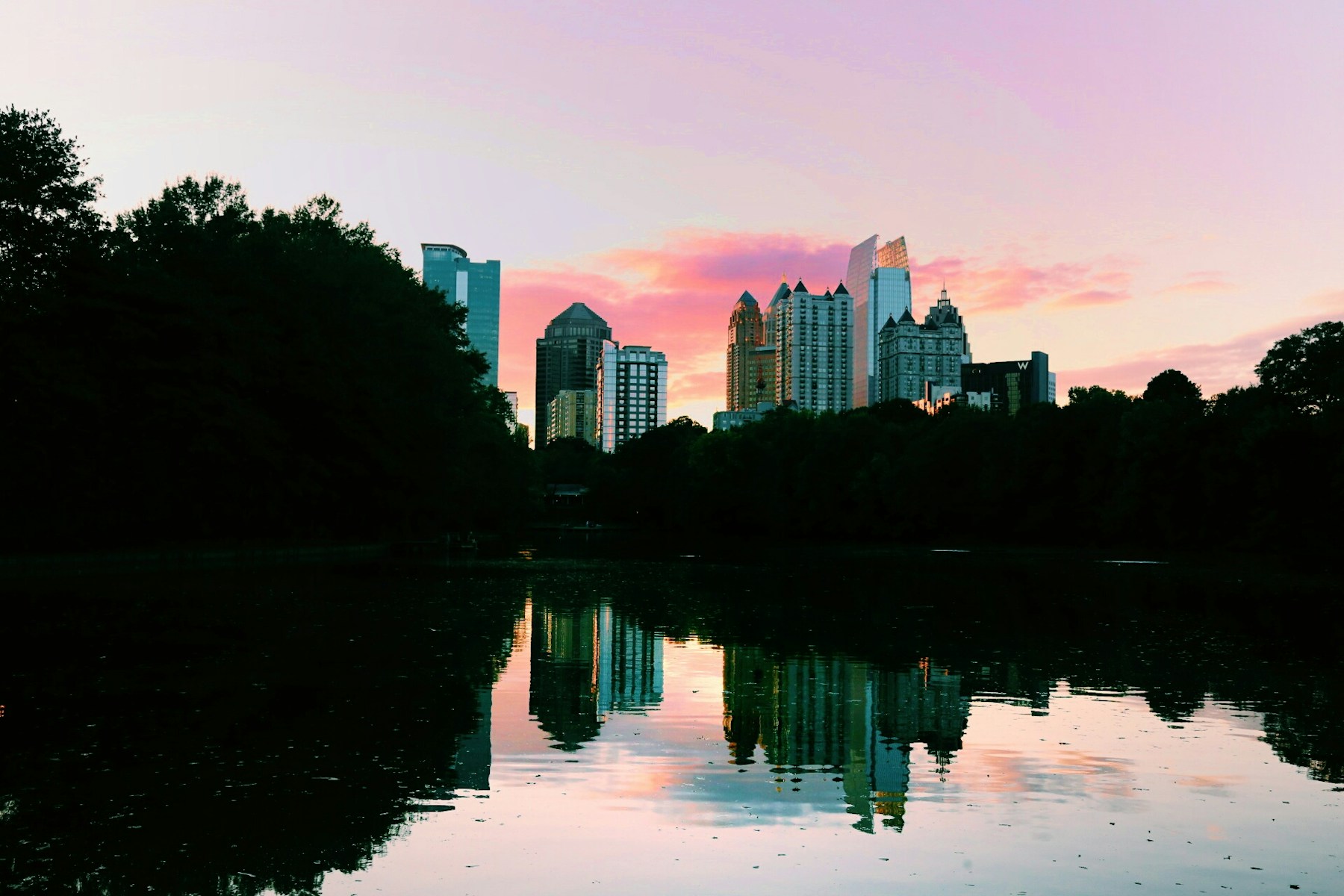 Atlanta skyline reflected in Piedmont Park lake at sunset