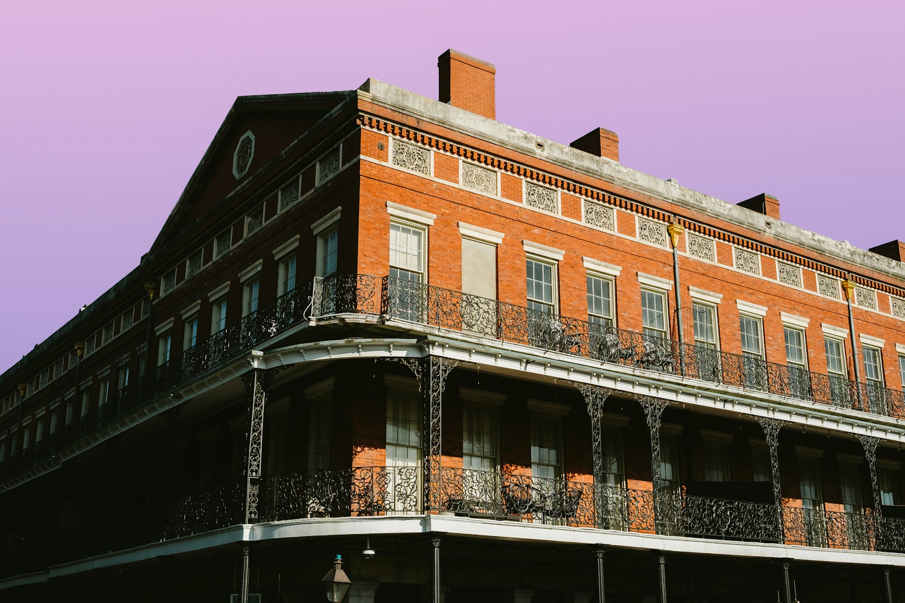 French Quarter iron balconies beneath a purple evening sky