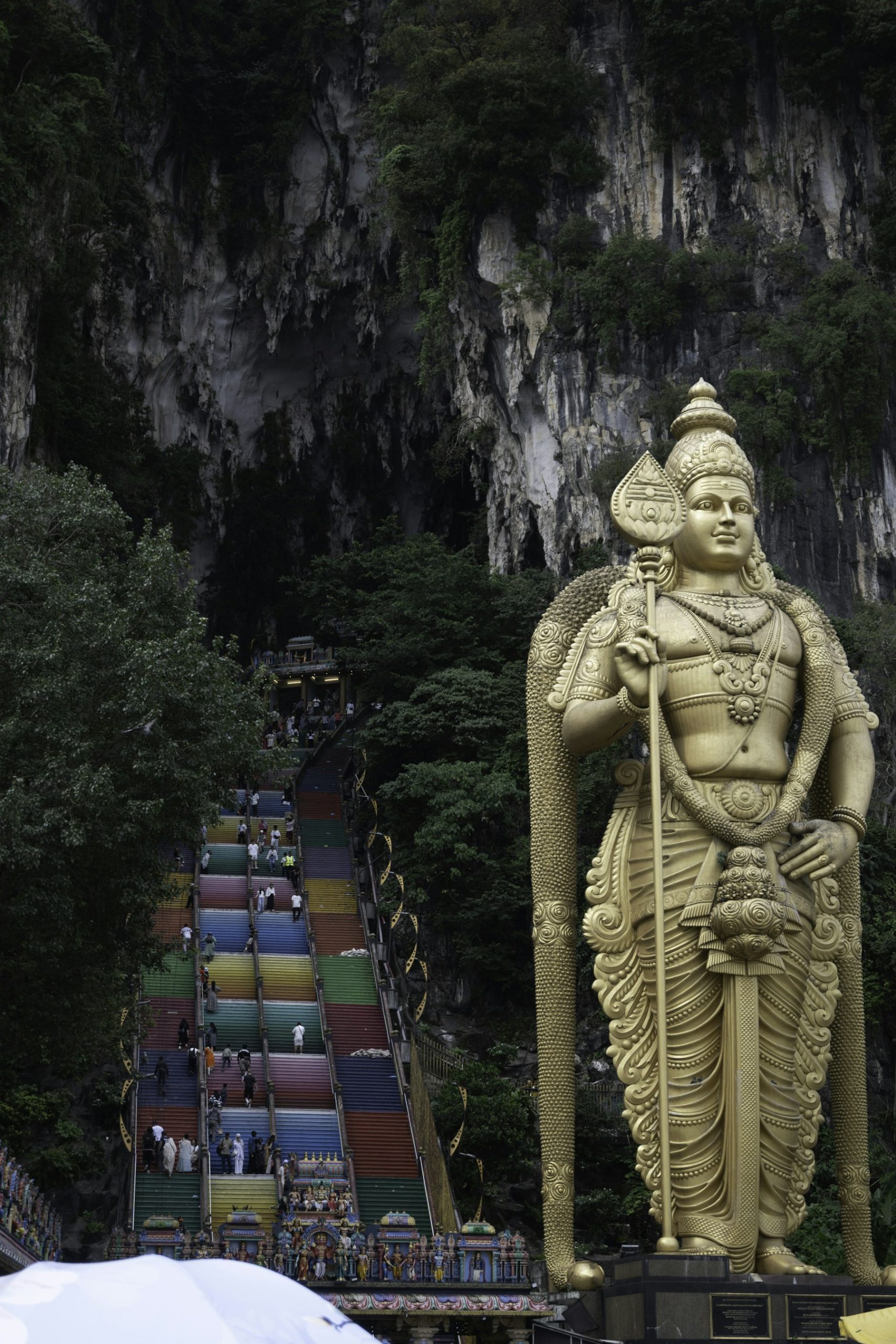 Murugan statue beside the colorful staircase at Batu Caves.