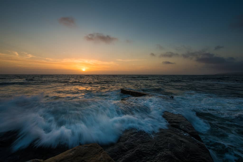 Waves breaking over rocks at Sunset Cliffs at sunset