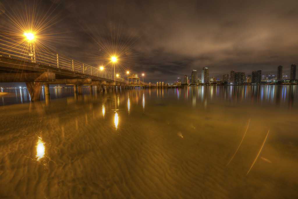 San Diego skyline and pier reflected in shallow water at night