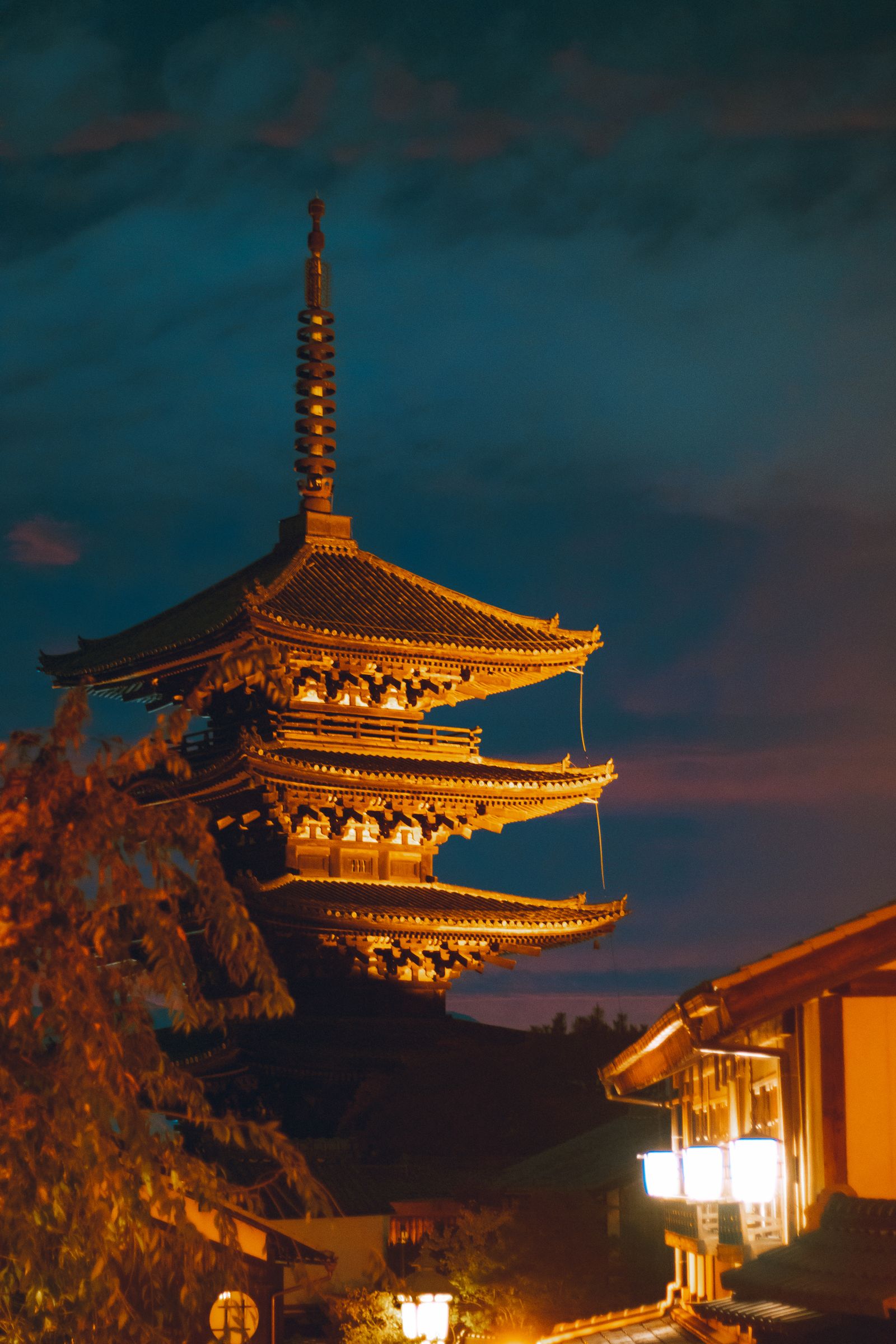 Illuminated Yasaka Pagoda against a deep blue dusk sky in Kyoto